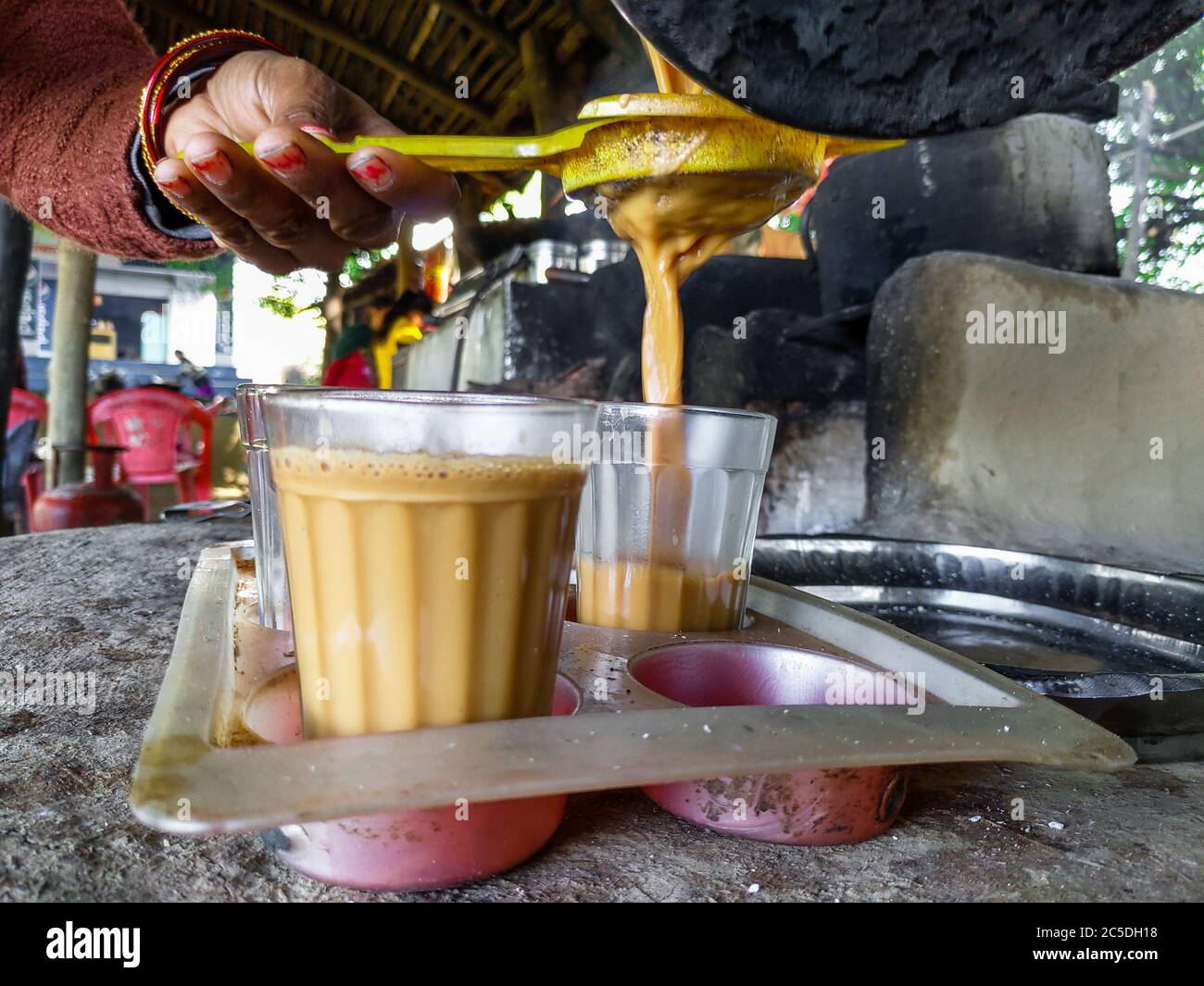 EDITORIAL DATED :19th february 2020 LOCATION :dehradun uttarakhand India. A tea seller in rural India pouring tea into a glass, close up shot. Stock Photo