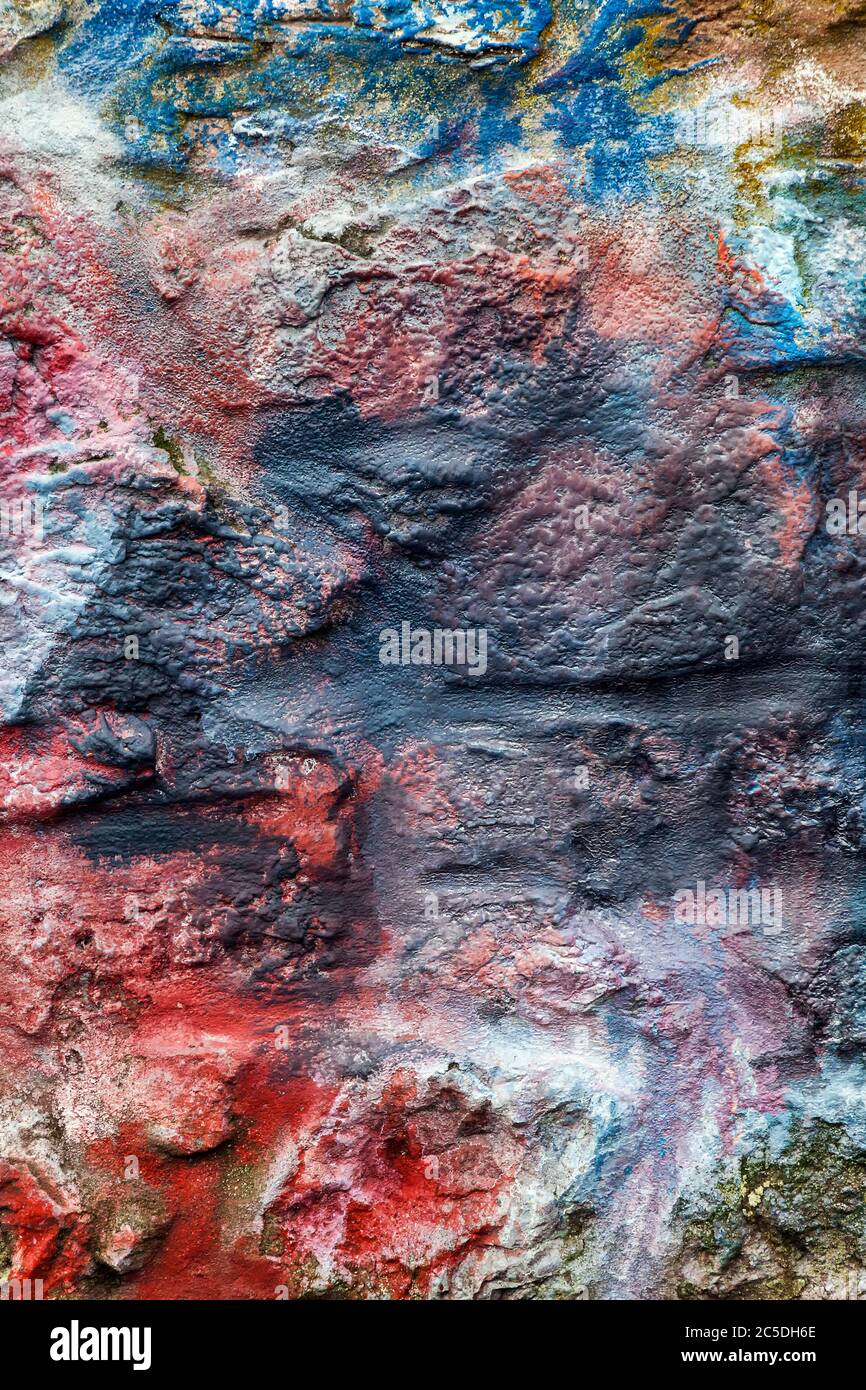 Old abstract red blue multi coloured painted stone brick wall texture background Stock Photo