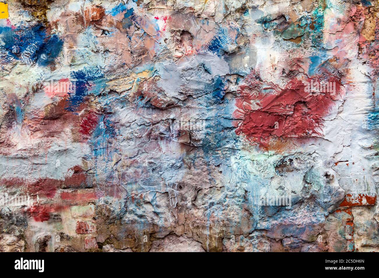 Old abstract red blue multi coloured painted stone brick wall texture background Stock Photo