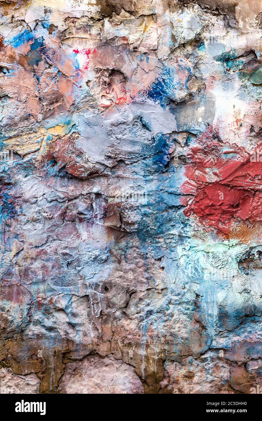 Old abstract red blue multi coloured painted stone brick wall texture background Stock Photo