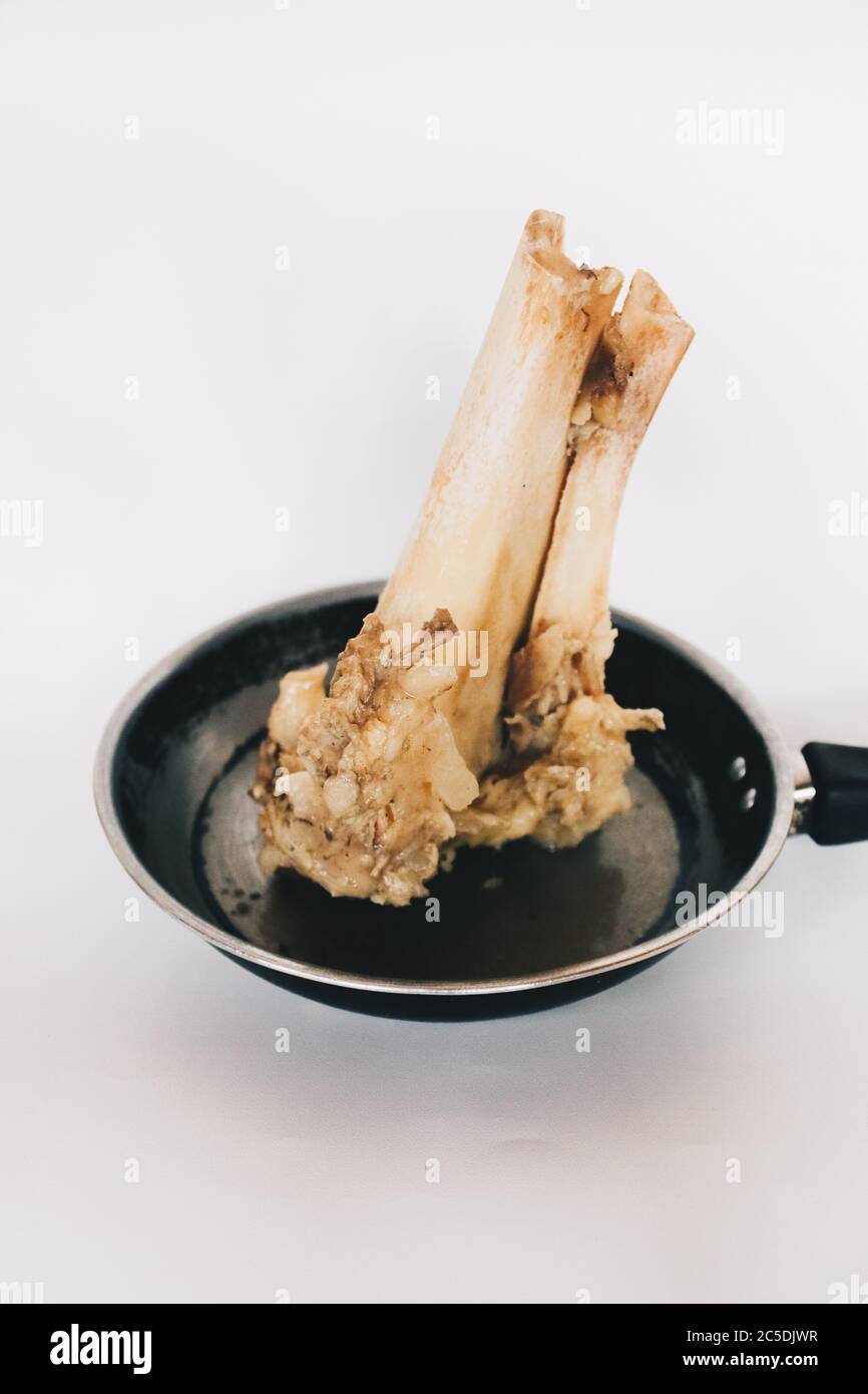 Raw stew beef bone soup in a pan isolated on white background. Stock Photo