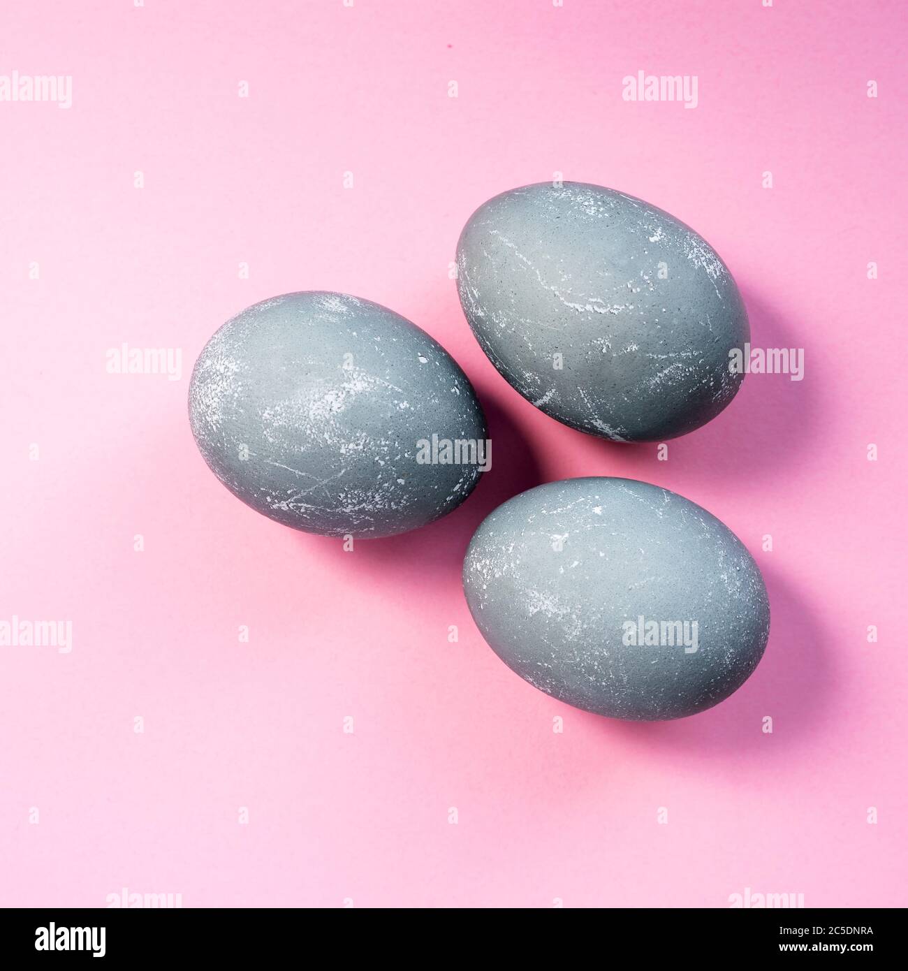 Three gray colored easter eggs on pink background. Top view, flat lay. Copy space. Happy Easter concept Stock Photo