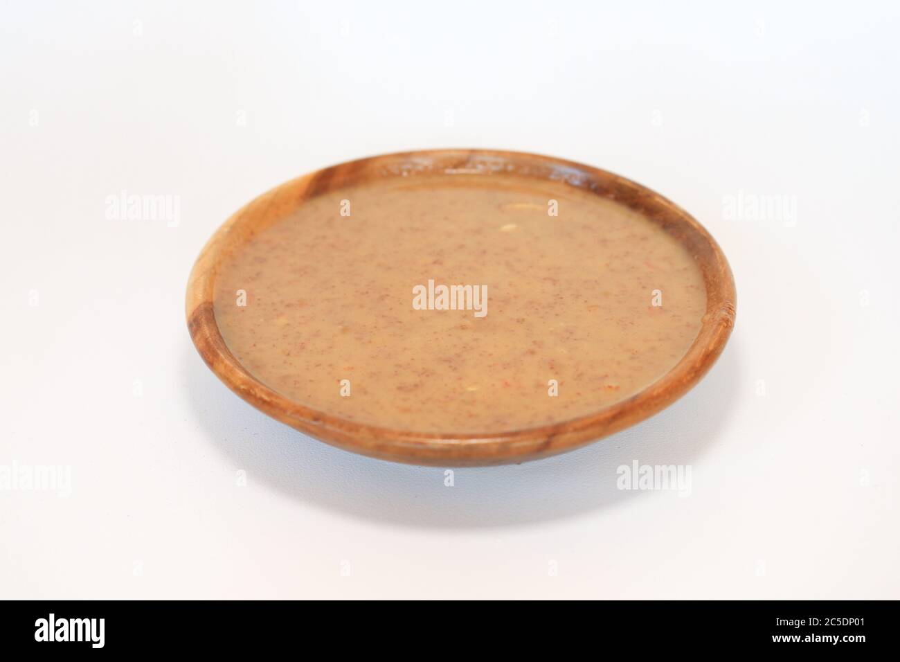 Peanut Sauce in bowl isolated on white background. Usually use for satay. Southeast Asian dipping sauce made with coconut milk and peanuts Stock Photo
