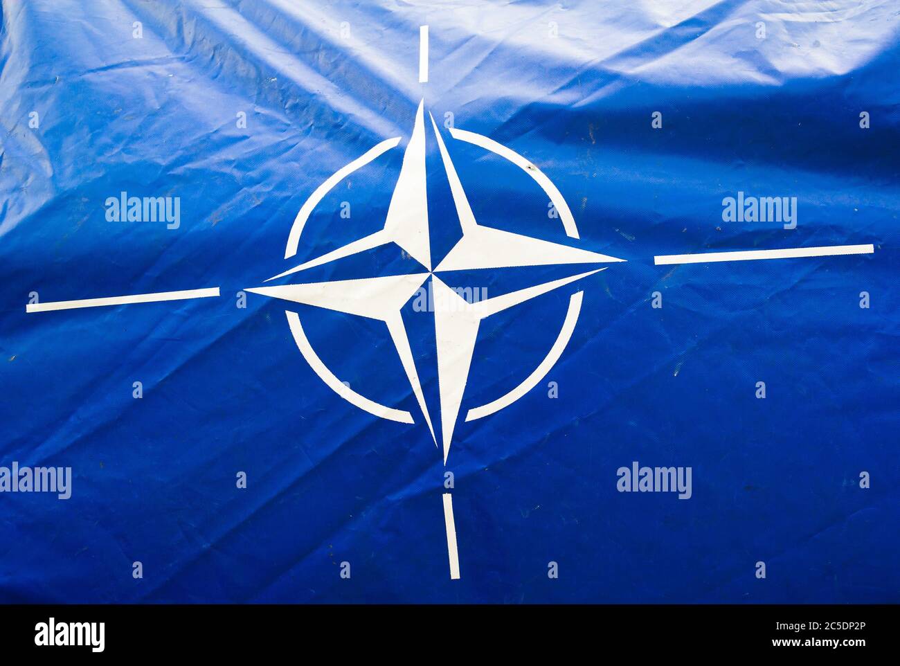 Ostrava, Czechia - September 18, 2016: Dirty and wrinkled blue canvas with flag of NATO ( North Atlantic Treaty Organization ). Military alliance Stock Photo