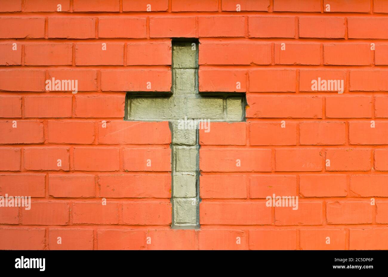 Wall and brickwork made of red brick. Cross between bricks symbol of