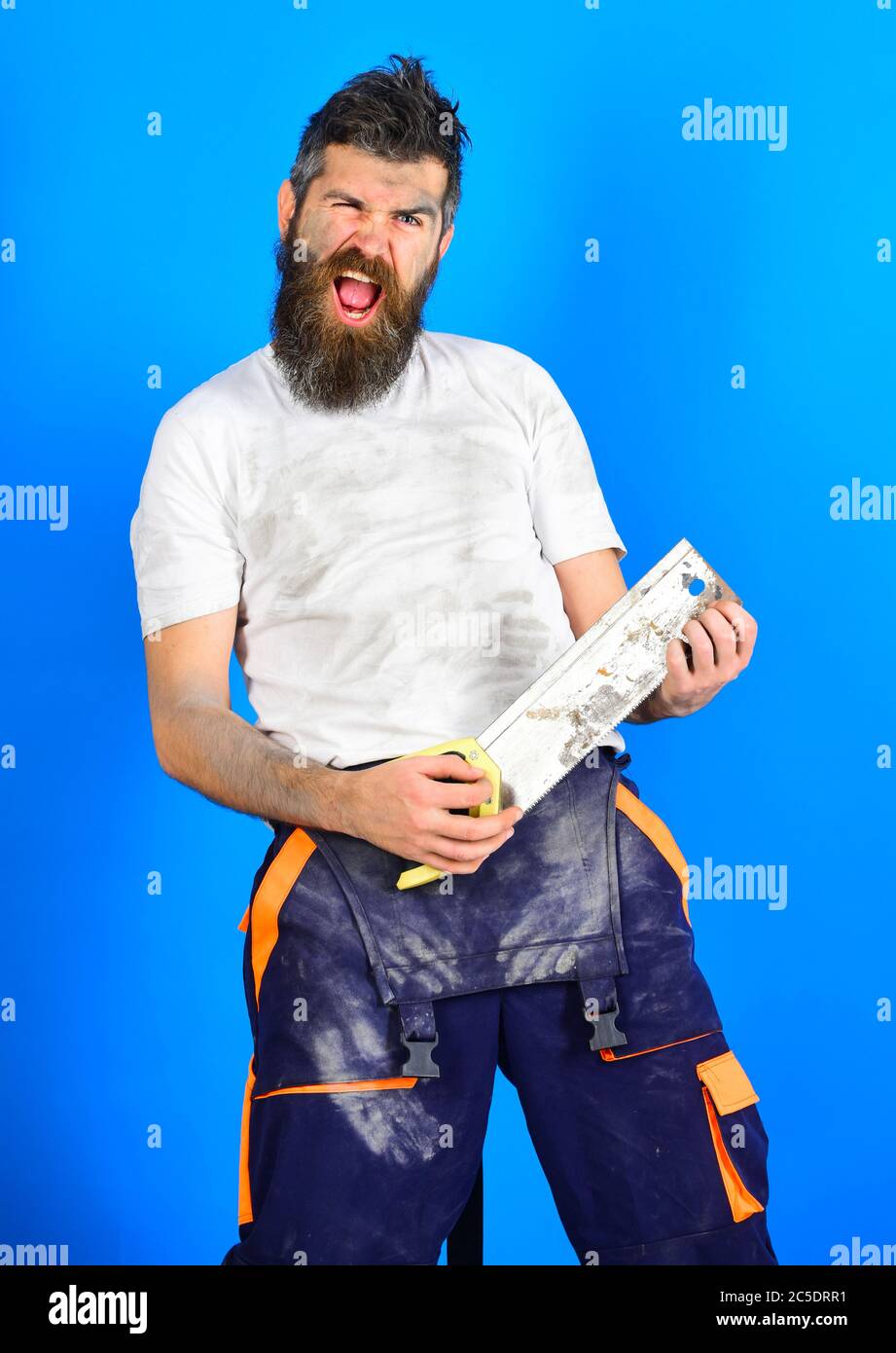 Guy Using Hacksaw Funny buider concept. Guy with beard covered with dust. Builder, worker ...