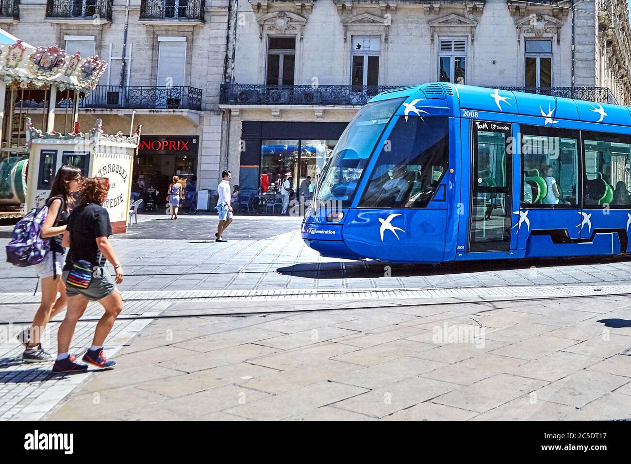 MONTPELLIER, FRANCE - June 24, 2015: Architecture of Place de la Comedie. Pedestrians and blue tram. City public transport on street Stock Photo