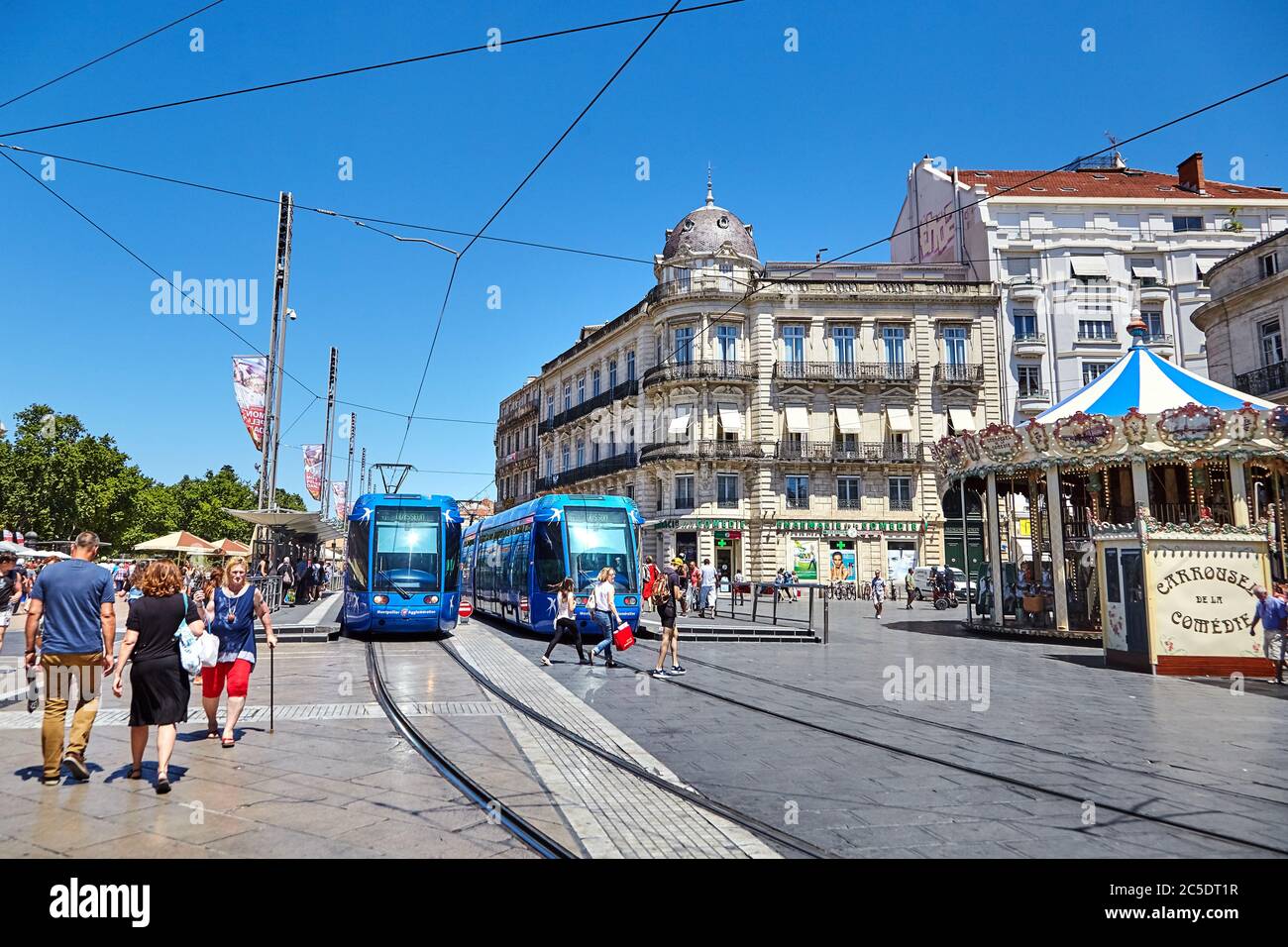MONTPELLIER, FRANCE - June 24, 2015: Architecture of Place de la Comedie and the carousel. People crossing the road through tram ways. City public tra Stock Photo