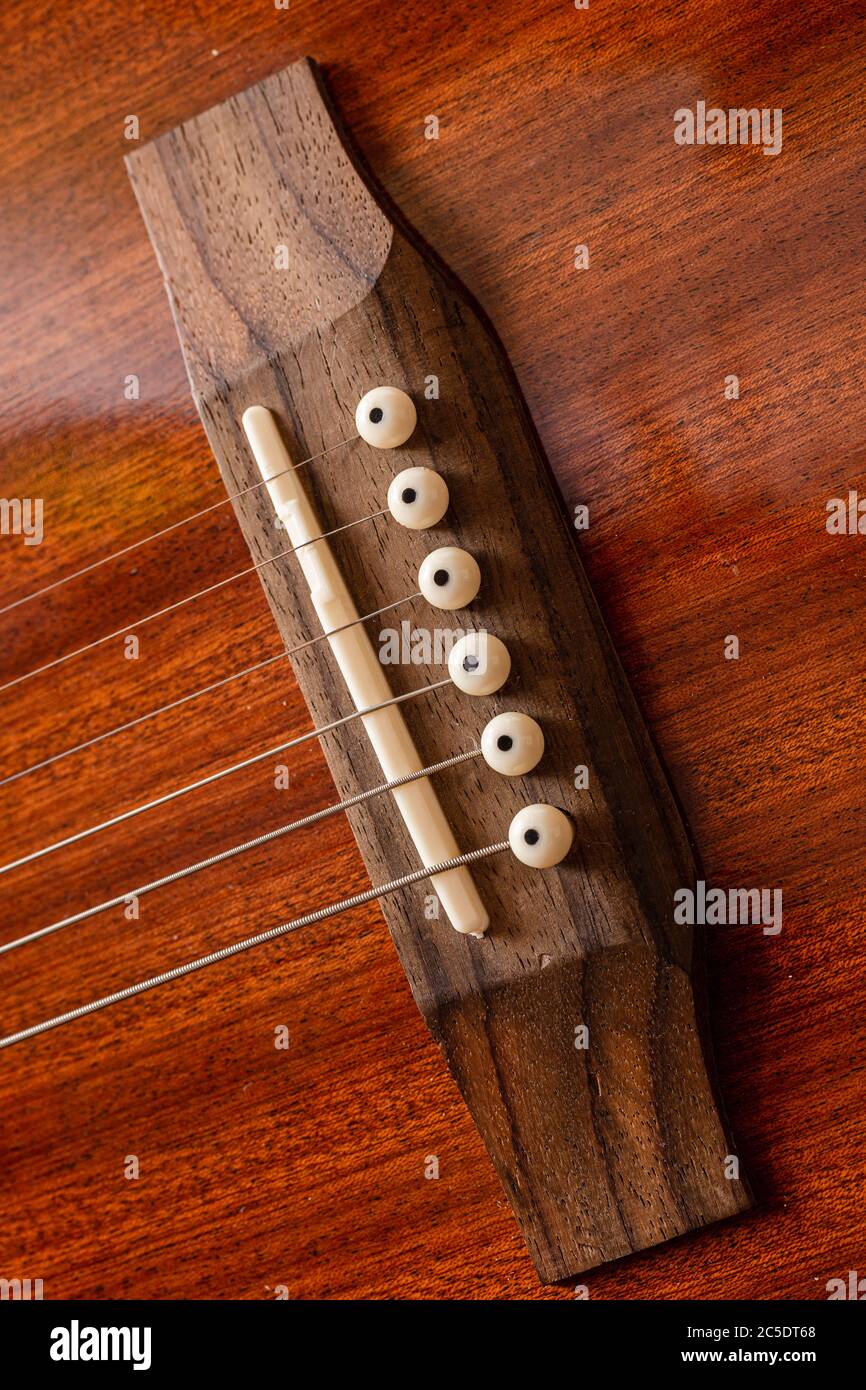 Acoustic Guitar Bridge Metal strings wooden musical instrument. Guitar Strap Studs. Stock Photo