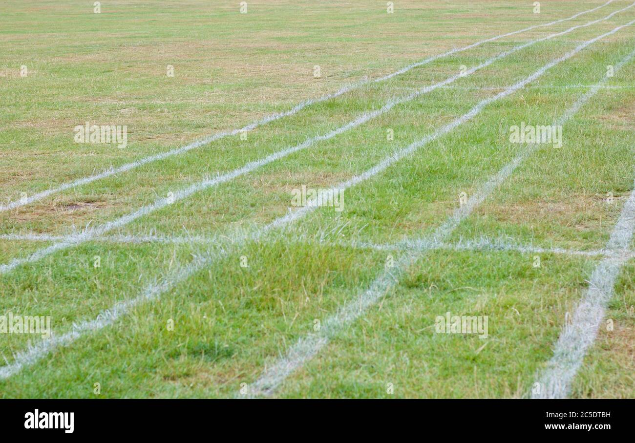 Athletics tracks marked onto green field with space for copy Stock Photo