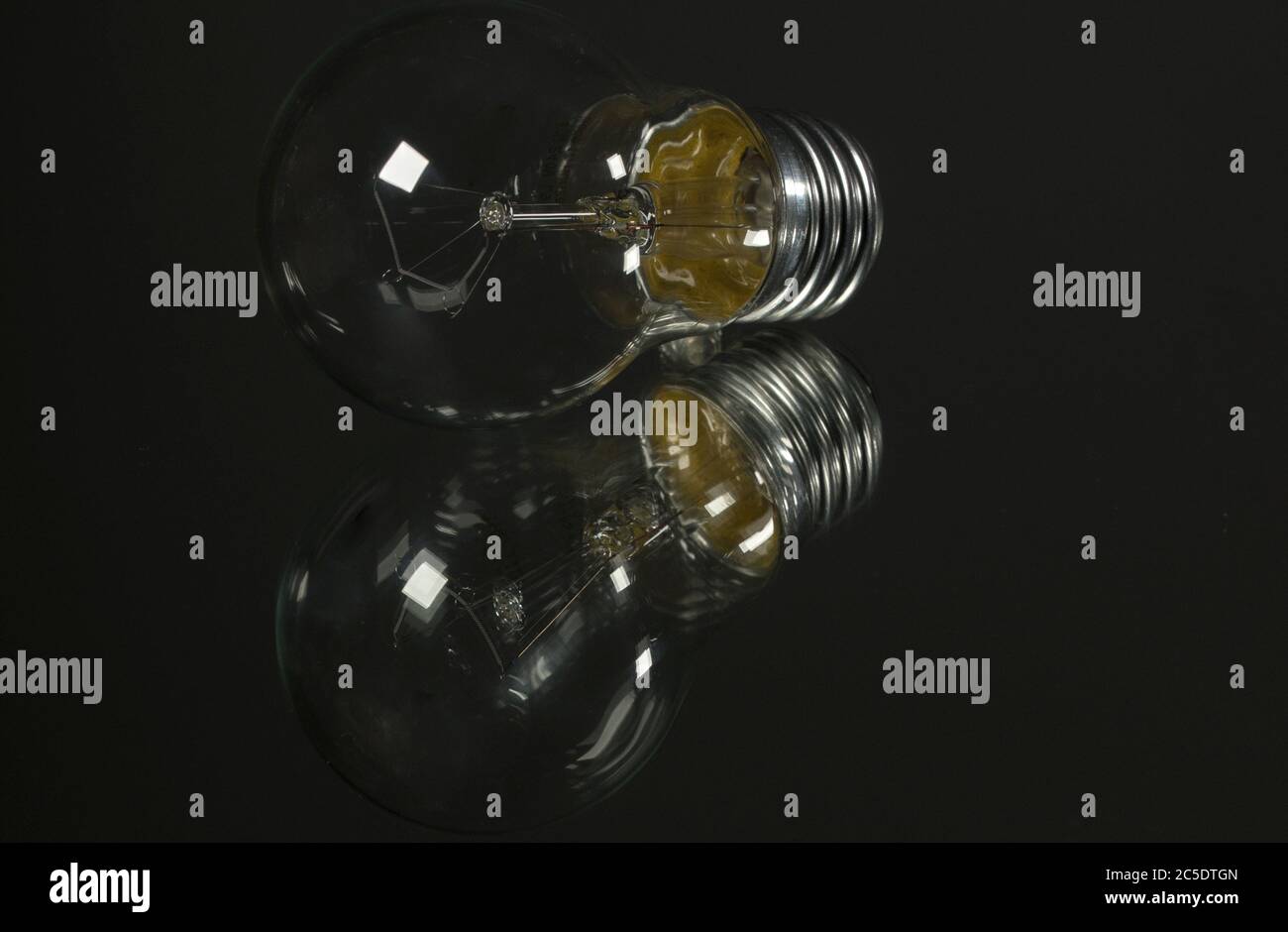 An old incandescent light bulb on black background Stock Photo