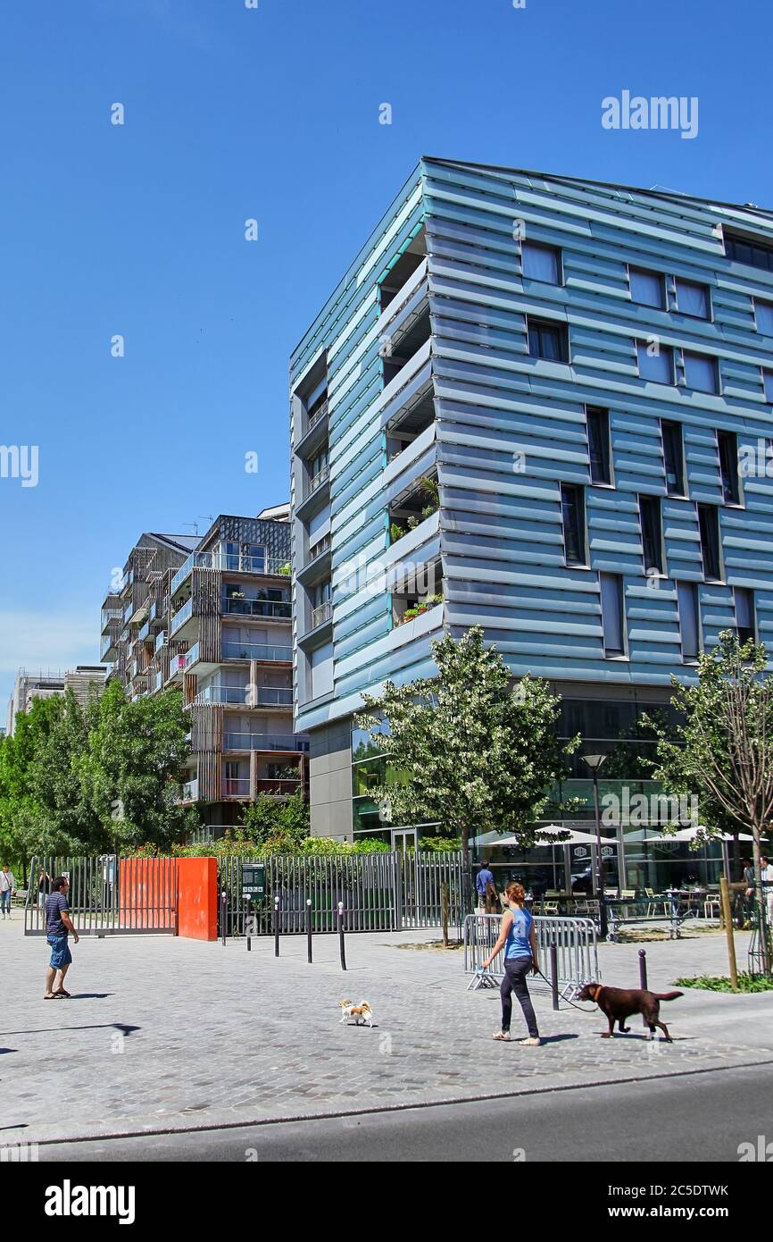 Paris, France - June 28, 2015: Eco-Quartier Clichy-Batignolles. New Modern Architecture. Park Martin Luther King. The girl is walking the dogs Stock Photo