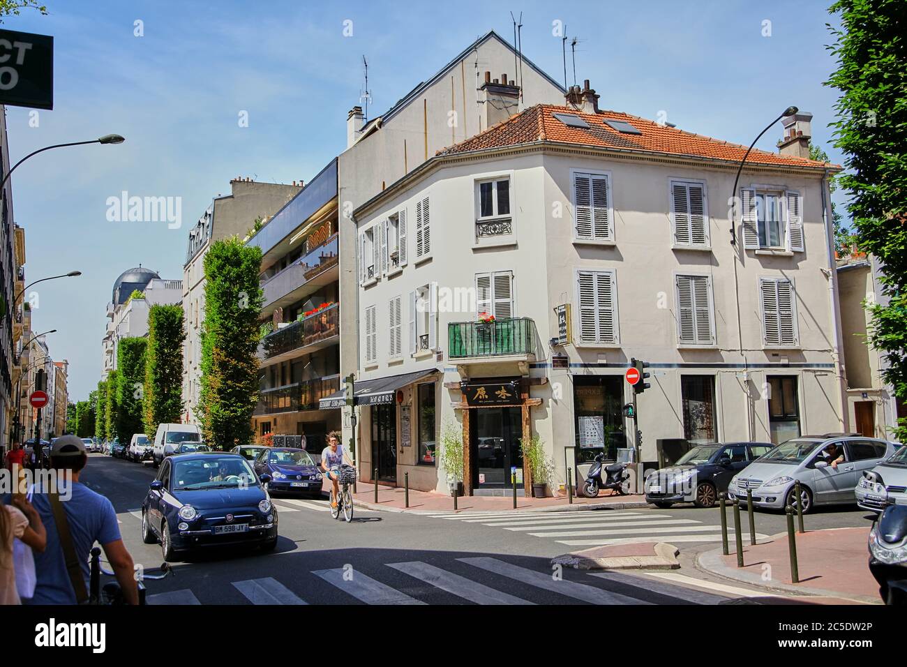 Levallois-Perret, France - June 28, 2015: Intersection of Rue Rivay and Rue Camille Pelletan. Facade of the building with a Japanese restaurant. Peopl Stock Photo