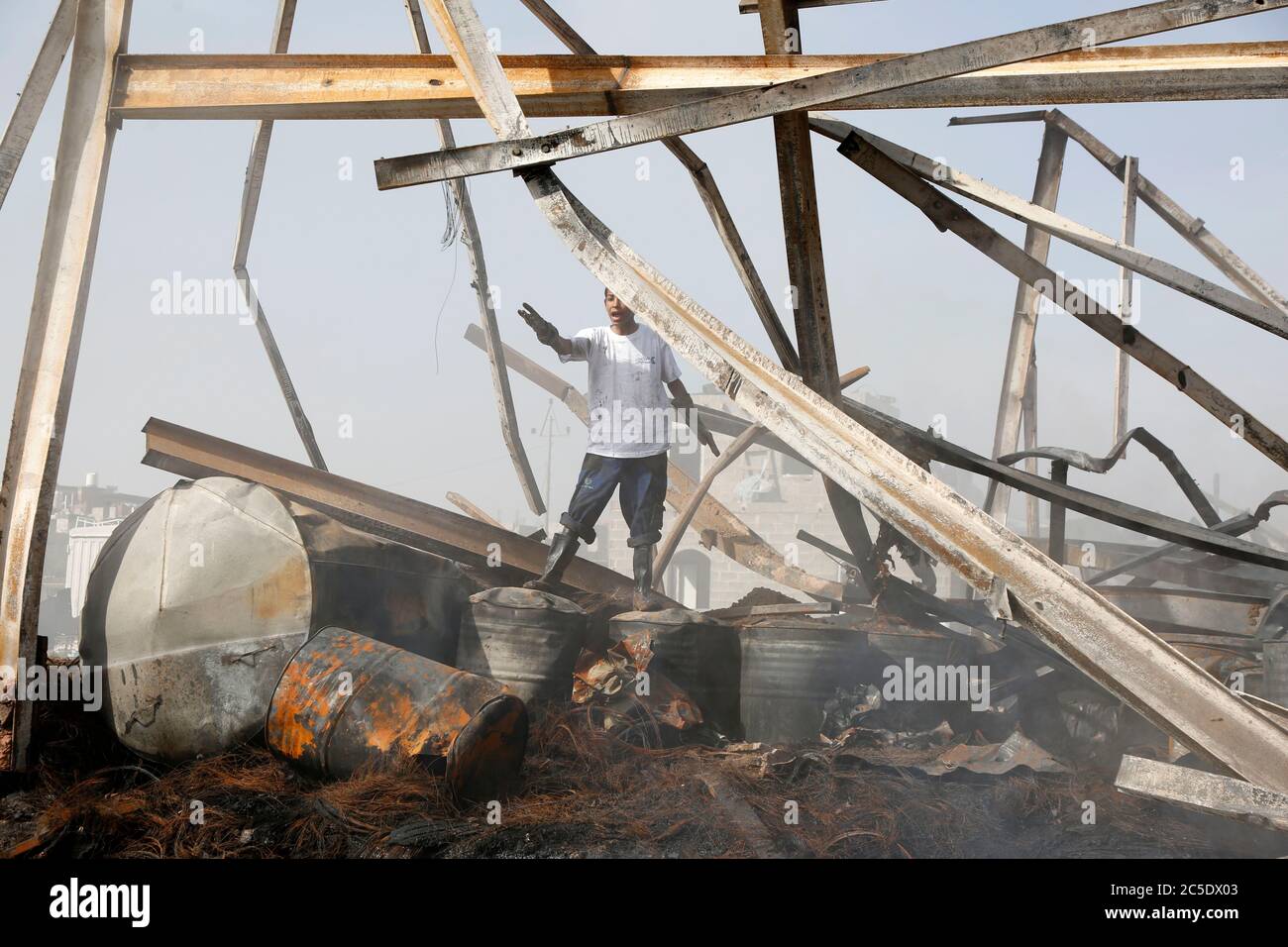 Sanaa, Yemen. 2nd July, 2020. A boy inspects a warehouse after it was hit by airstrikes in Sanaa, Yemen, on July 2, 2020. The Saudi-led coalition on Wednesday launched a series of airstrikes on the Yemeni capital Sanaa, which is under Houthi control, the Houthi-run al-Masirah TV reported. Credit: Mohammed Mohammed/Xinhua/Alamy Live News Stock Photo