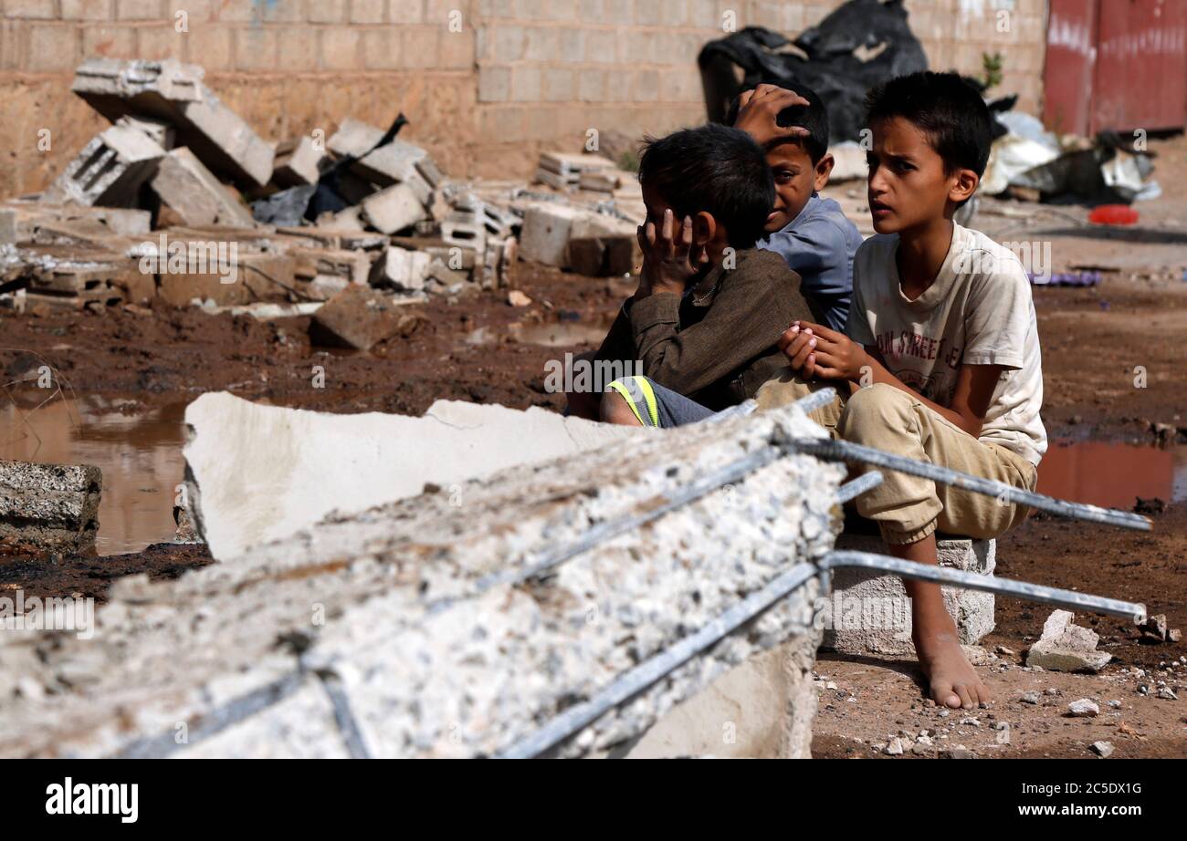 Sanaa, Yemen. 2nd July, 2020. Children sit on the rubble of a warehouse after it was hit by airstrikes in Sanaa, Yemen, on July 2, 2020. The Saudi-led coalition on Wednesday launched a series of airstrikes on the Yemeni capital Sanaa, which is under Houthi control, the Houthi-run al-Masirah TV reported. Credit: Mohammed Mohammed/Xinhua/Alamy Live News Stock Photo