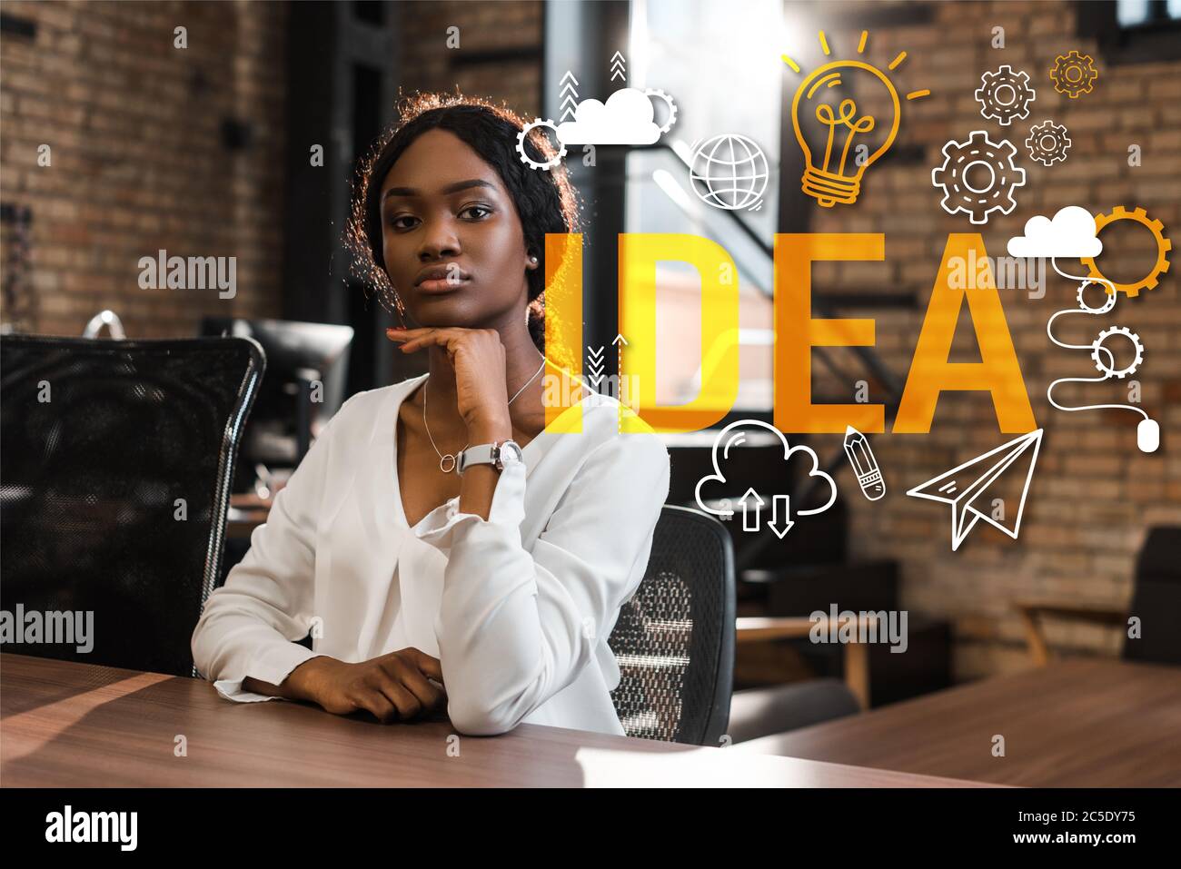 attractive, thoughtful african american businesswoman sitting at desk ...