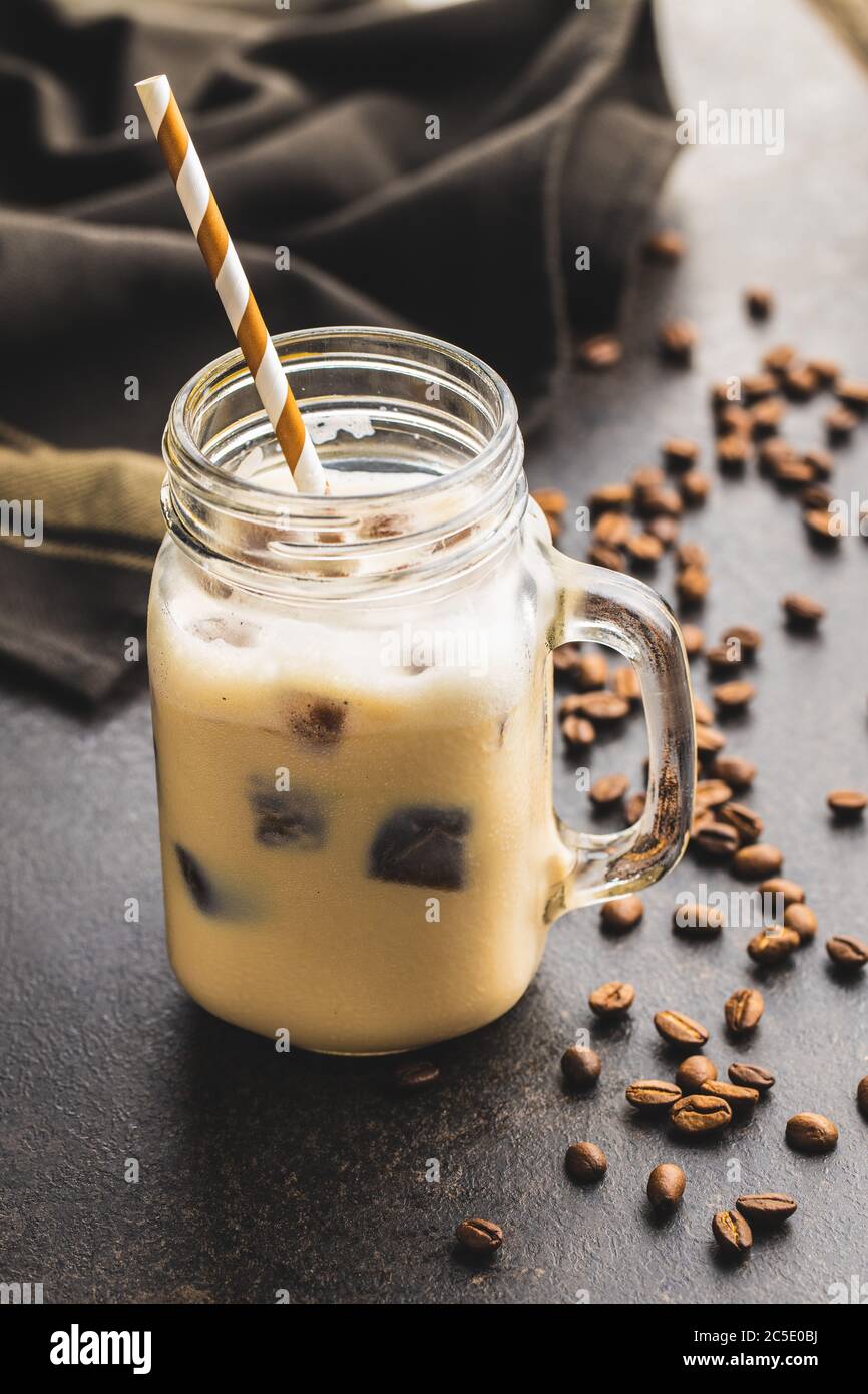 Iced coffee with coffee ice cubes on black table. Stock Photo