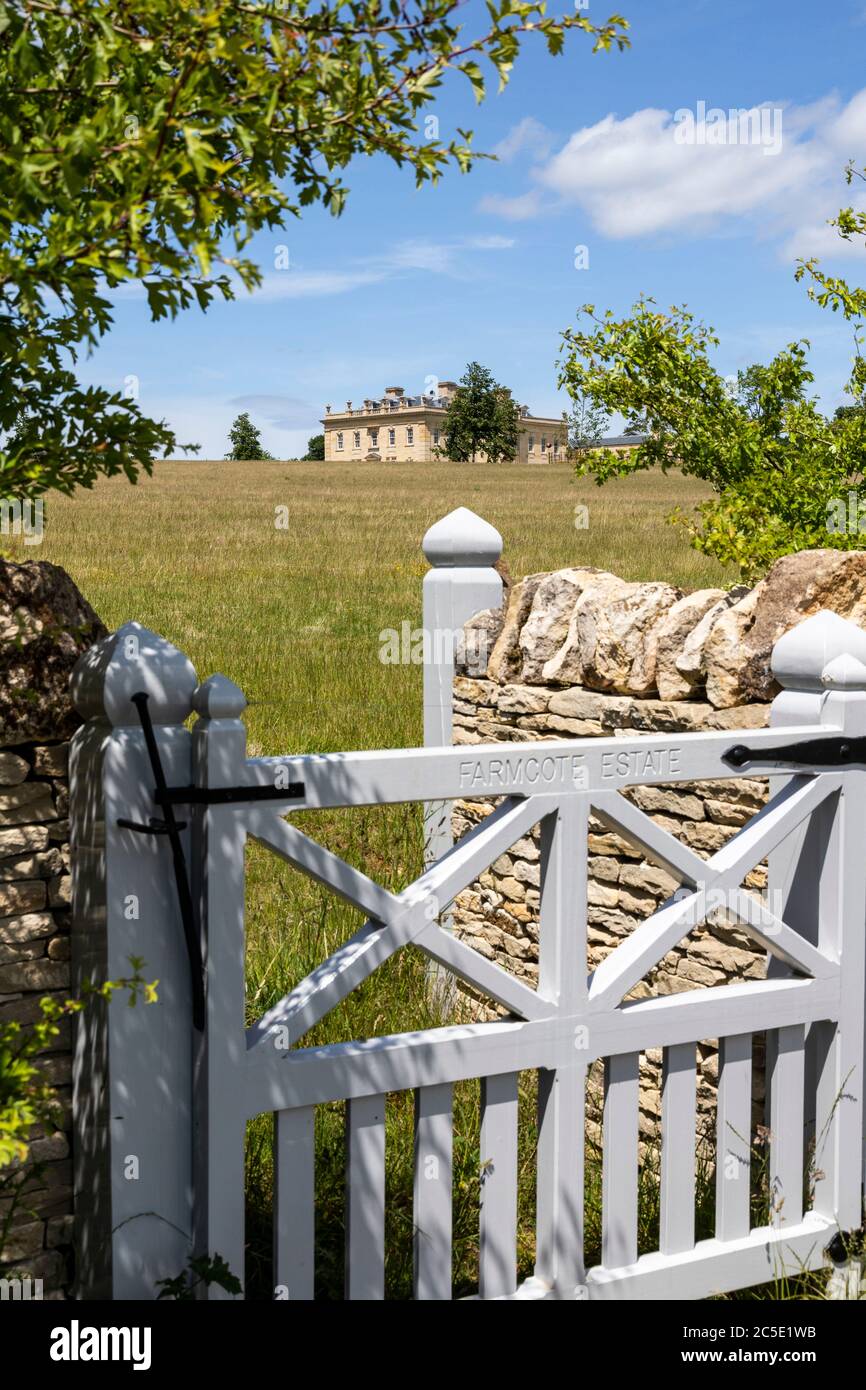 A glimpse of a classical country house built since 2012 on the Farmcote Estate viewed from Campden Lane on the Cotswold Hills, Gloucestershire UK. Stock Photo