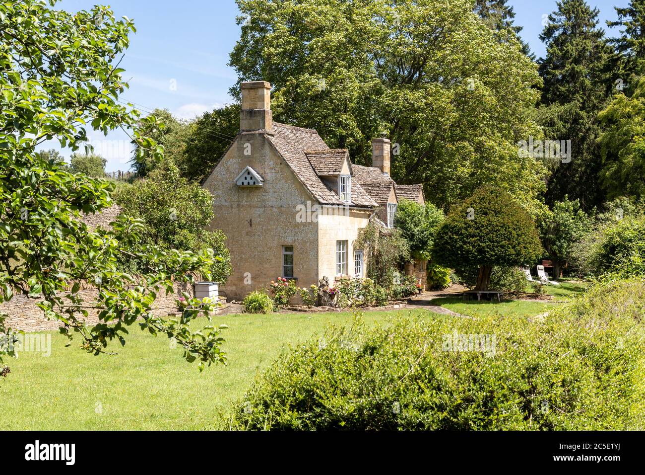 A typical small stone cottage beside the Winchcombe Way on the Cotswold Hills near the hamlet of Farmcote, Gloucestershire UK Stock Photo