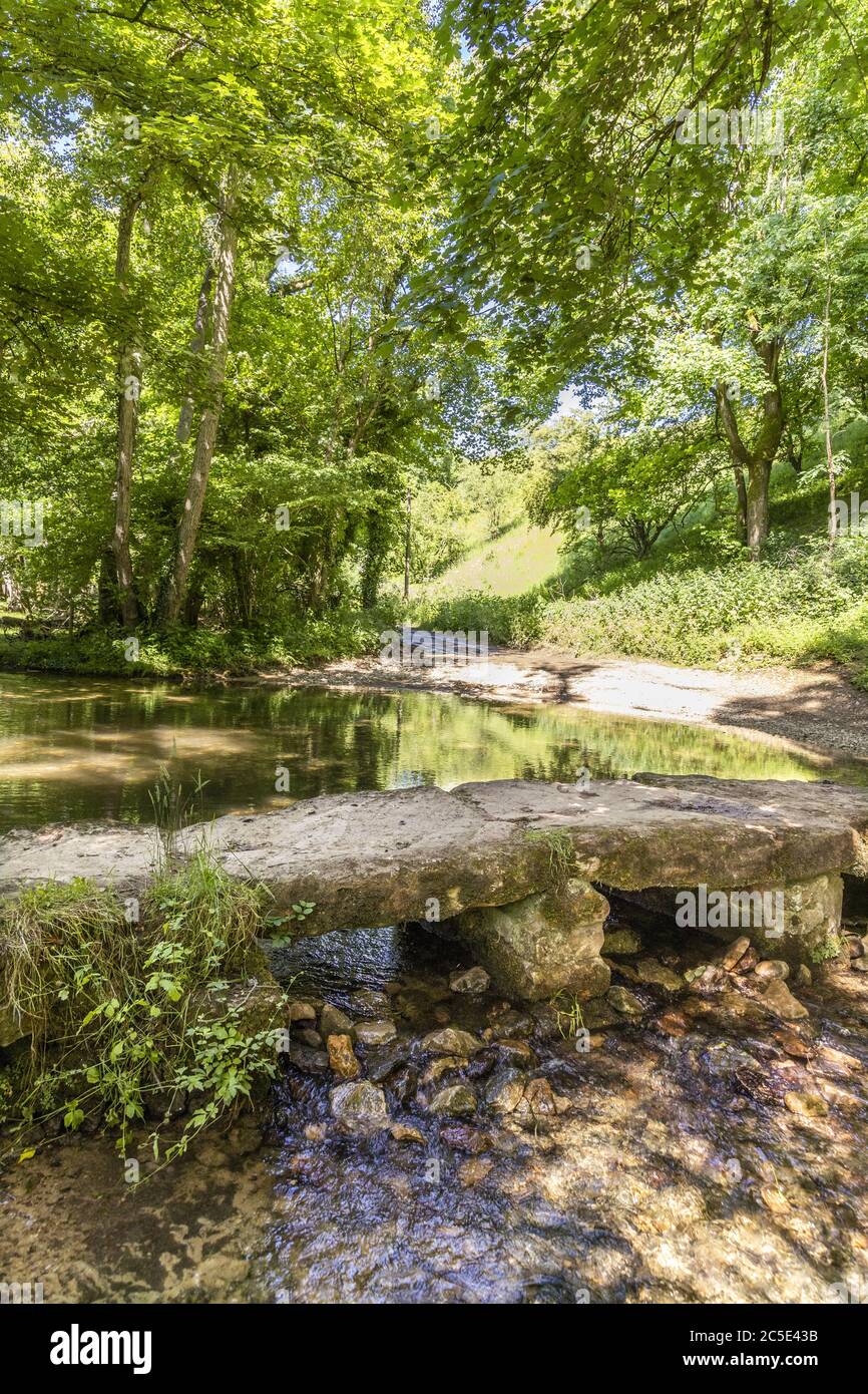 The ford and clapper bridge over the infant River Windrush in the Cotswold village of Kineton, Gloucestershire UK Stock Photo