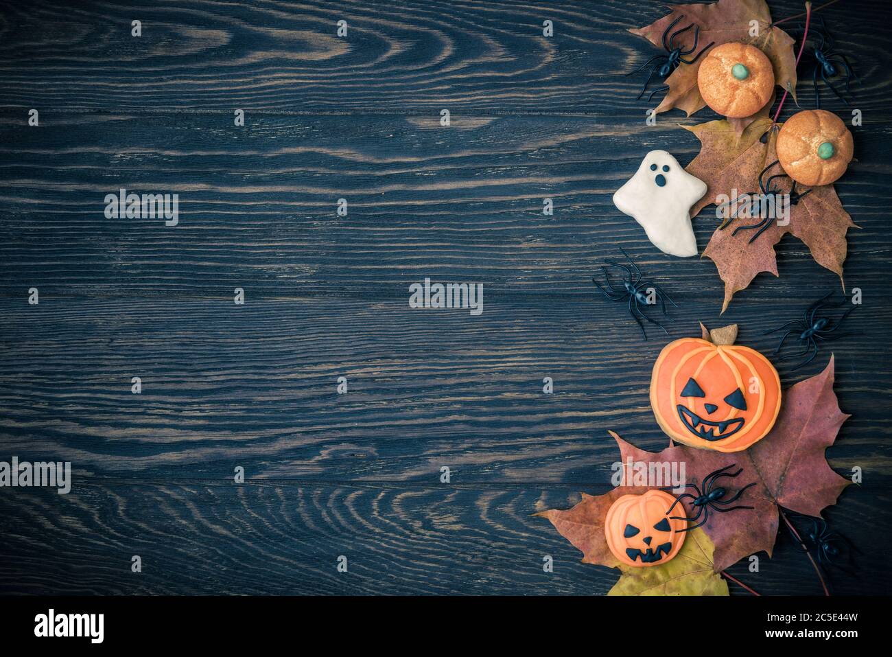 Halloween holiday background with cookies, leaves and spiders. View from above. Stock Photo