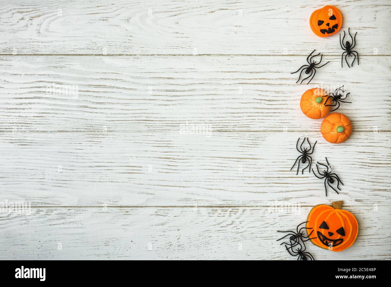 Halloween holiday background with pumpkin cookies and spiders. View from above. Stock Photo