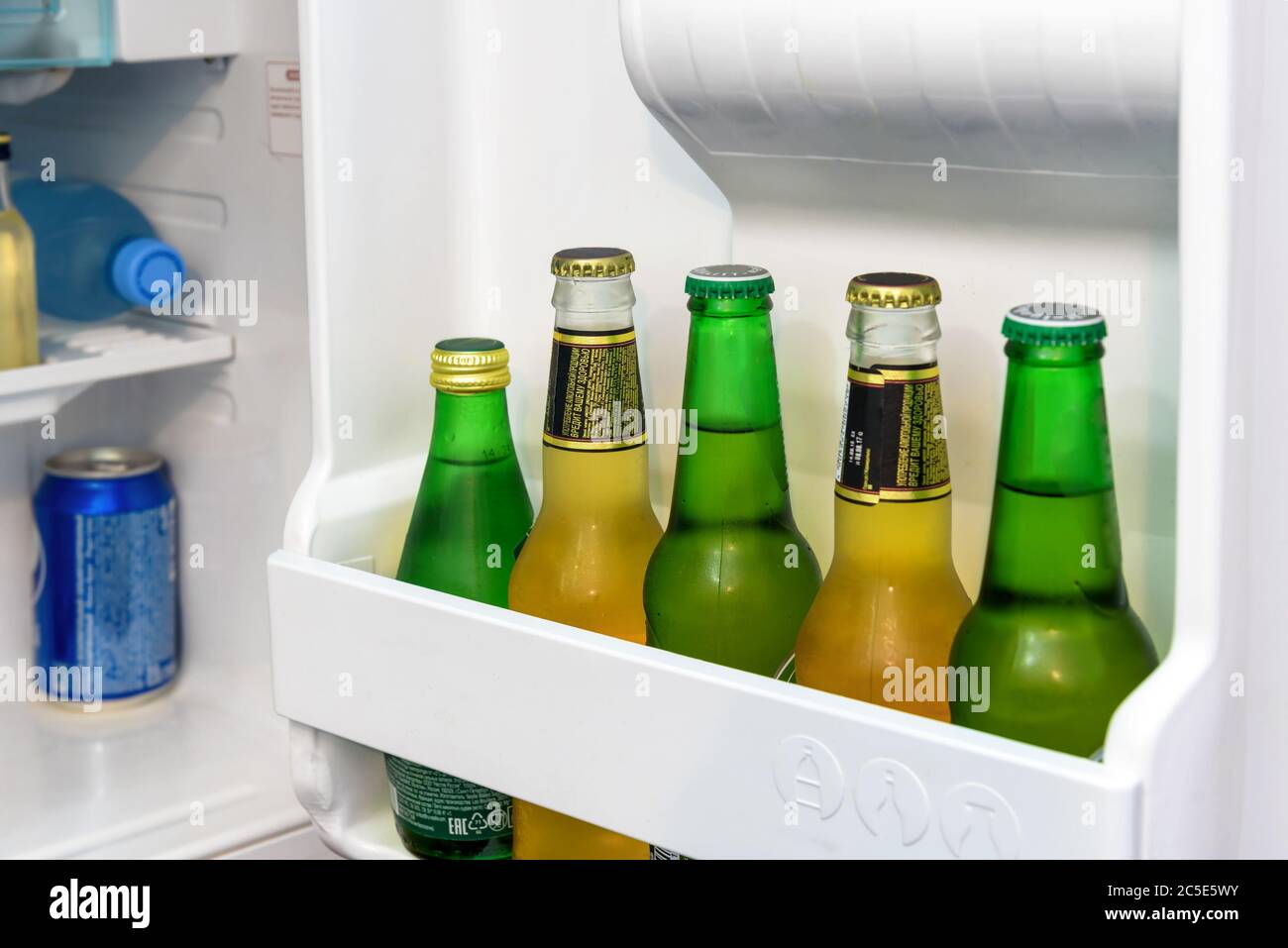 Mini fridge full of bottles of beer and water in a hotel room Stock Photo