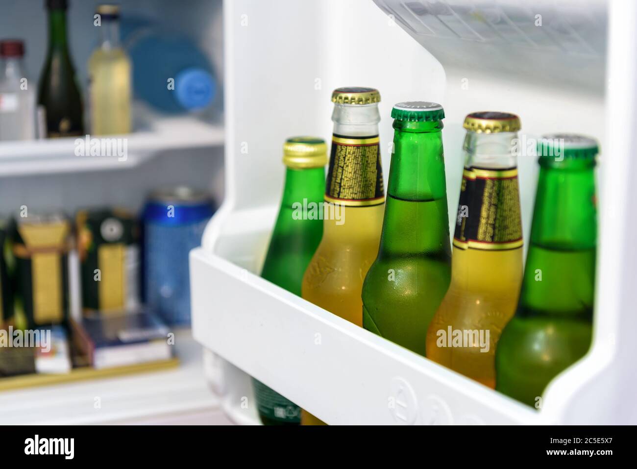 Mini fridge full of bottles of beer, juice and water in a hotel room Stock Photo