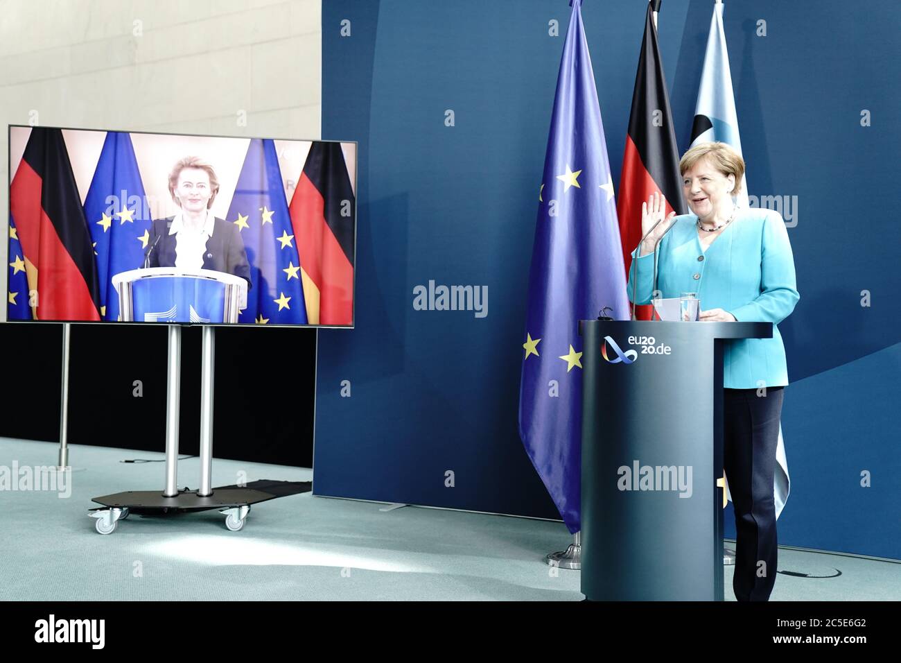 02 July 2020, Berlin: Federal Chancellor Angela Merkel (CDU) makes a statement to the press in the foyer of the Federal Chancellery and waves to EU Commission President Ursula von der Leyen (CDU), who has joined in by video. One day after taking over the Presidency of the Council, Merkel joined the President of the EU Commission, the three executive Vice-Presidents, the Commissioner for External Relations and the Commissioner for Internal Affairs. They have coordinated the work programme for the beginning of the Federal Republic's EU Presidency. Photo: Kay Nietfeld/dpa Stock Photo