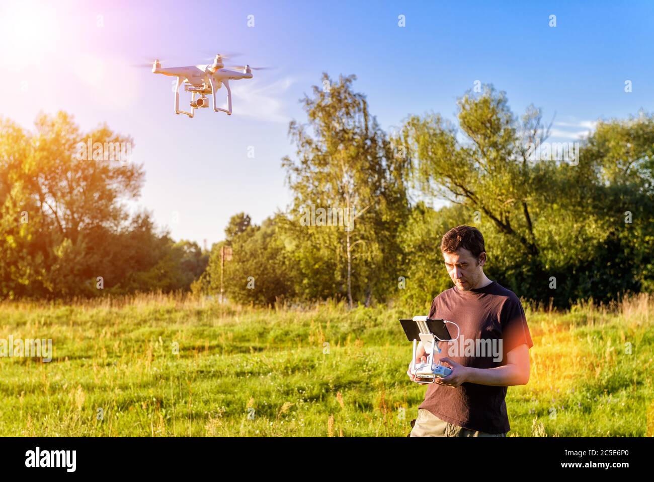 MOSCOW - AUGUST 9, 2016: Man operating a drone quad copter with onboard digital camera in the park Stock Photo