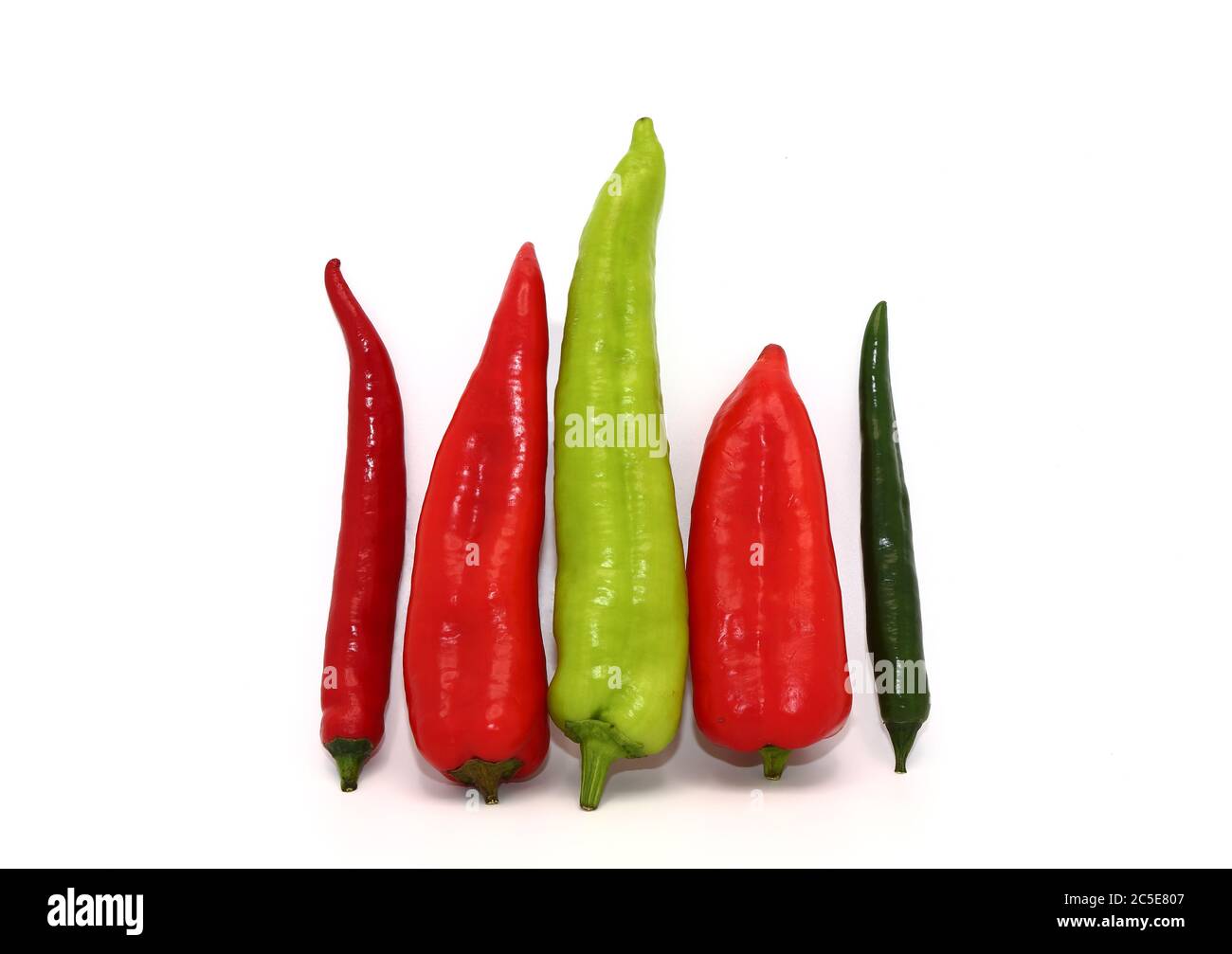 Three chili peppers of red and green color on a light background. Natural product. Natural color. Close-up. Stock Photo
