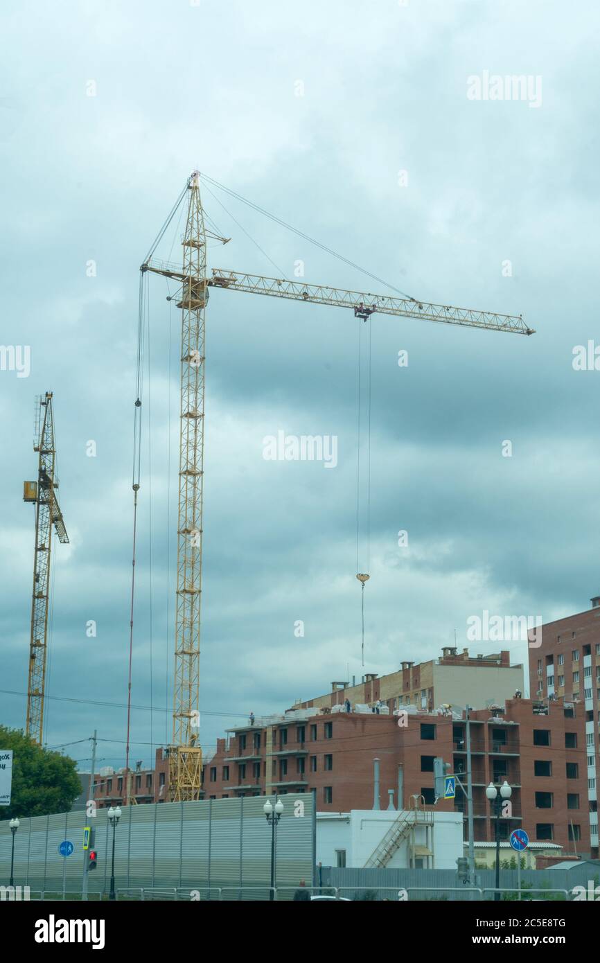 A crane on a construction site against a cloudy sky Stock Photo