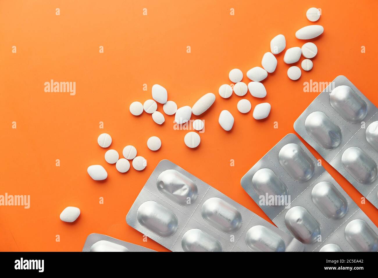 white pills and blister pack on orange background  Stock Photo