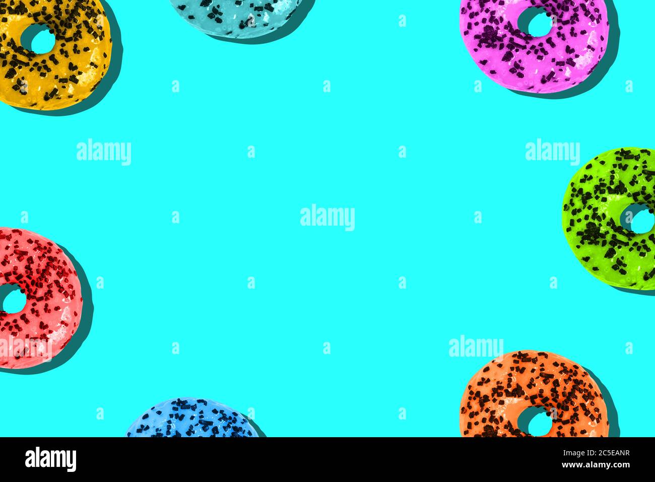 Donuts are colored on a bright background with a copy of the space. Unhealthy diet. Minimum summer template Stock Photo