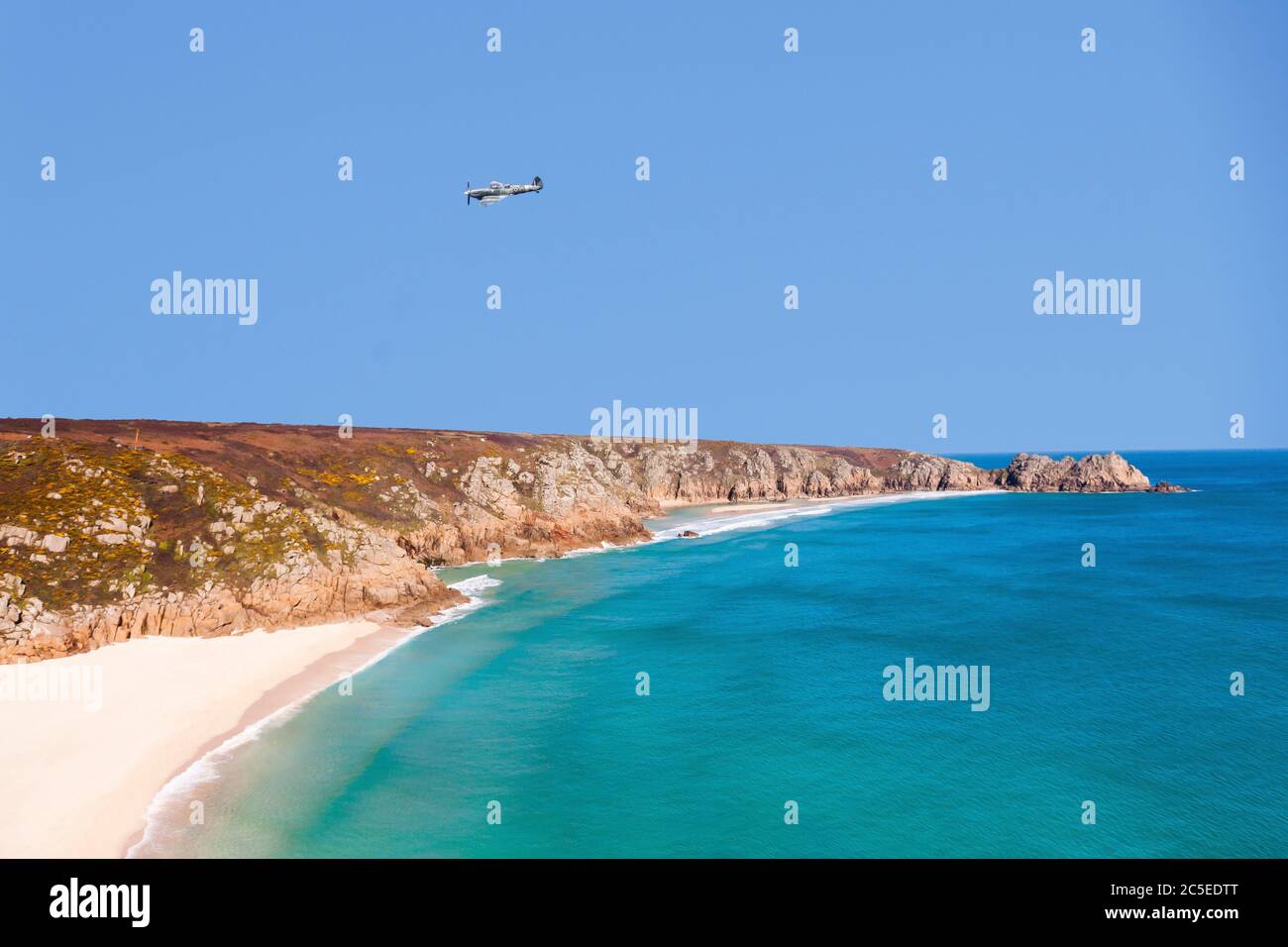 A Spitfire Aeroplane Flying over Porthcurno Beach, Porthcurno, Cornwall, South West, England, UK Stock Photo