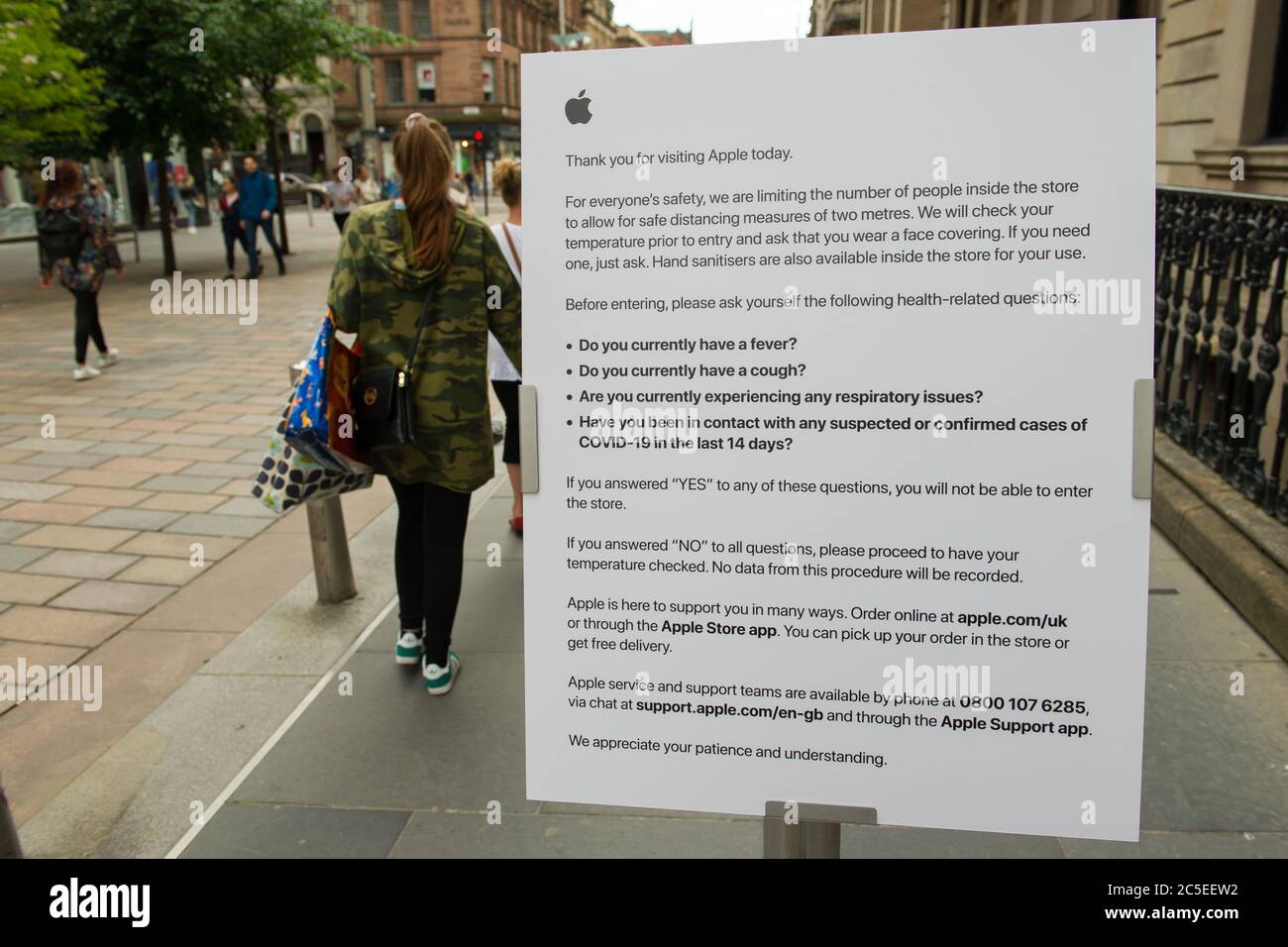 Glasgow, Scotland, UK. 2nd July, 2020. Pictured: Customer notice outside the Apple shop advising in taking temperatures and wearing a face mask. Scenes from Glasgows style mile, Buchanan Street shopping area, where more people are seen wearing face masks or home made face coverings. Nicola Sturgeon announced earlier today that wearing a face covering is to become mandatory in shops from 10th July next week. Face coverings are already mandatory when taking public transport in a bid to slow down the spread of coronavirus. Credit: Colin Fisher/Alamy Live News Stock Photo