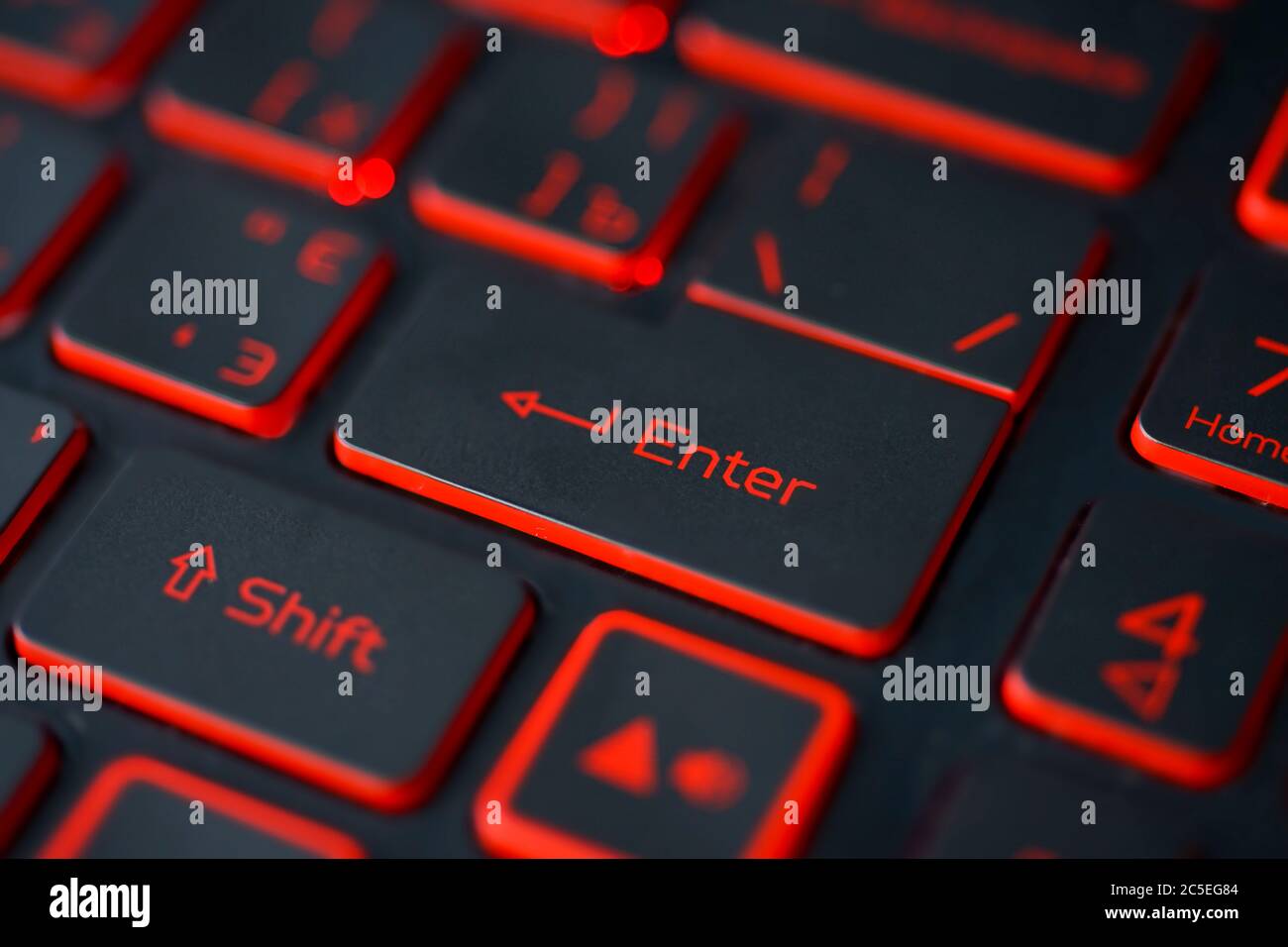 Red backlit computer keyboard macro shot of enter key Stock Photo - Alamy