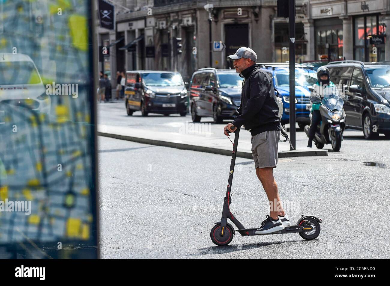 London, UK. 2 July 2020. A man rides a personal electric scooter (e-scooter)  in Regent Street. The Department of Transport will allow rental e-scooters  to become legal on roads in Great Britain