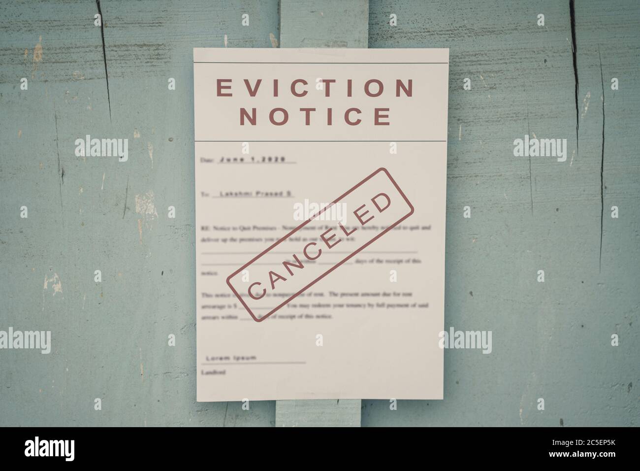 Canceled Foreclosed or eviction notice on a main door with blurred details of a house with vintage filter. Stock Photo
