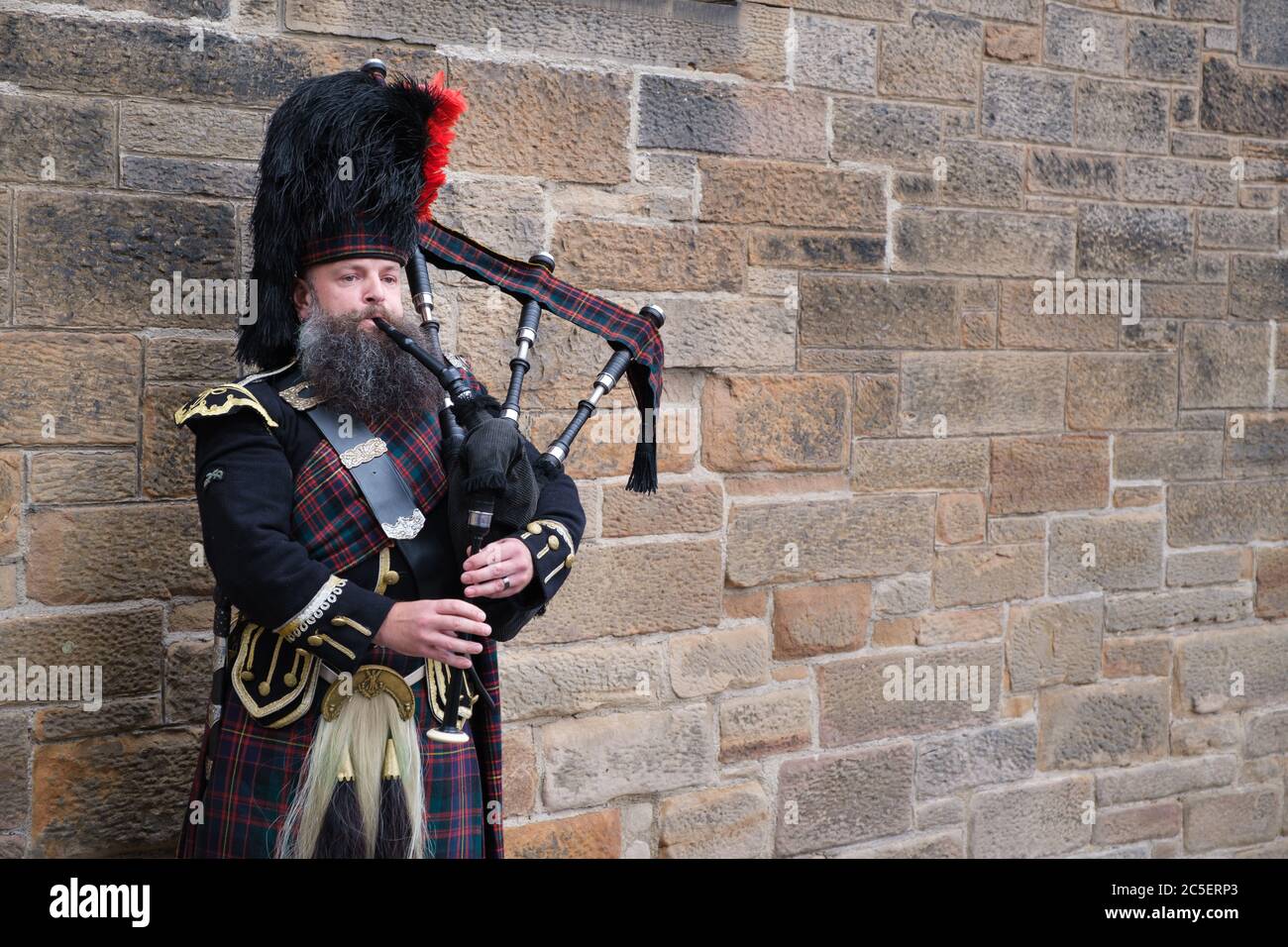 Man playing bagpipe in scottish traditional costume hires stock