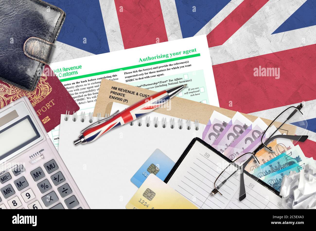 English form 64-8 Authorising your agent from HM revenue and customs lies on table with office items. HMRC paperwork and tax paying process in United Stock Photo
