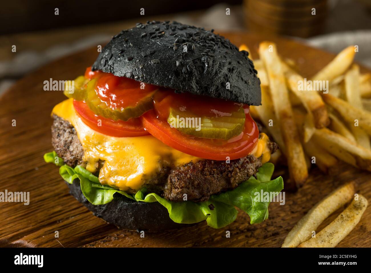 Homemade Cheeseburger with a Black Charcoal Bun and Fries Stock Photo