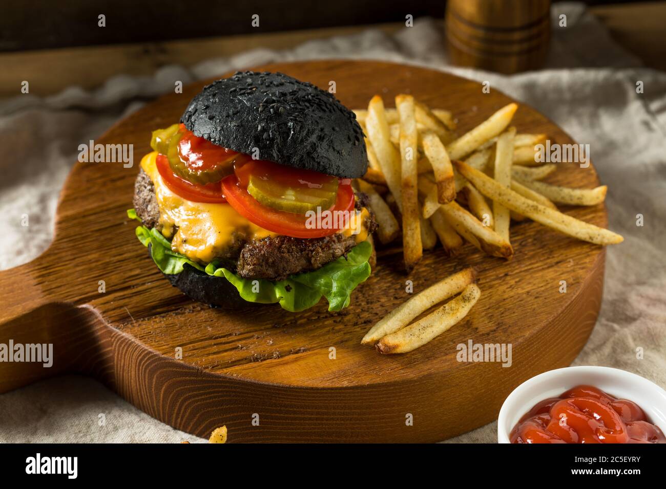 Homemade Cheeseburger with a Black Charcoal Bun and Fries Stock Photo