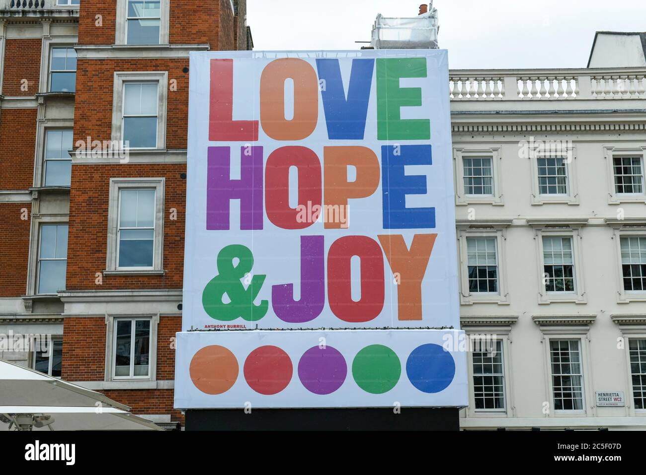 London, UK.  2 July 2020.  A poster displaying the text 'Love, Hope and Joy' overlooks The Piazza in Covent Garden.  The artwork by Anthony Burrill is his largest to date and celebrates the re-opening of the area to shoppers and businesses after certain coronavirus pandemic lockdown restrictions have been relaxed.  The work will be on show until October 2020.   Credit: Stephen Chung / Alamy Live News Stock Photo