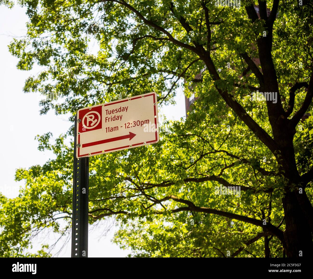 A sign designating the hours and days for alternate side of the street parking for street cleaning in the Chelsea neighborhood of New York on Tuesday, June 23, 2020. NY Mayor Bill De Blasio announced that the rules alternate side of the street parking will be revised enabling motorists to move their cars only one day a week.(© Richard B. Levine) Stock Photo