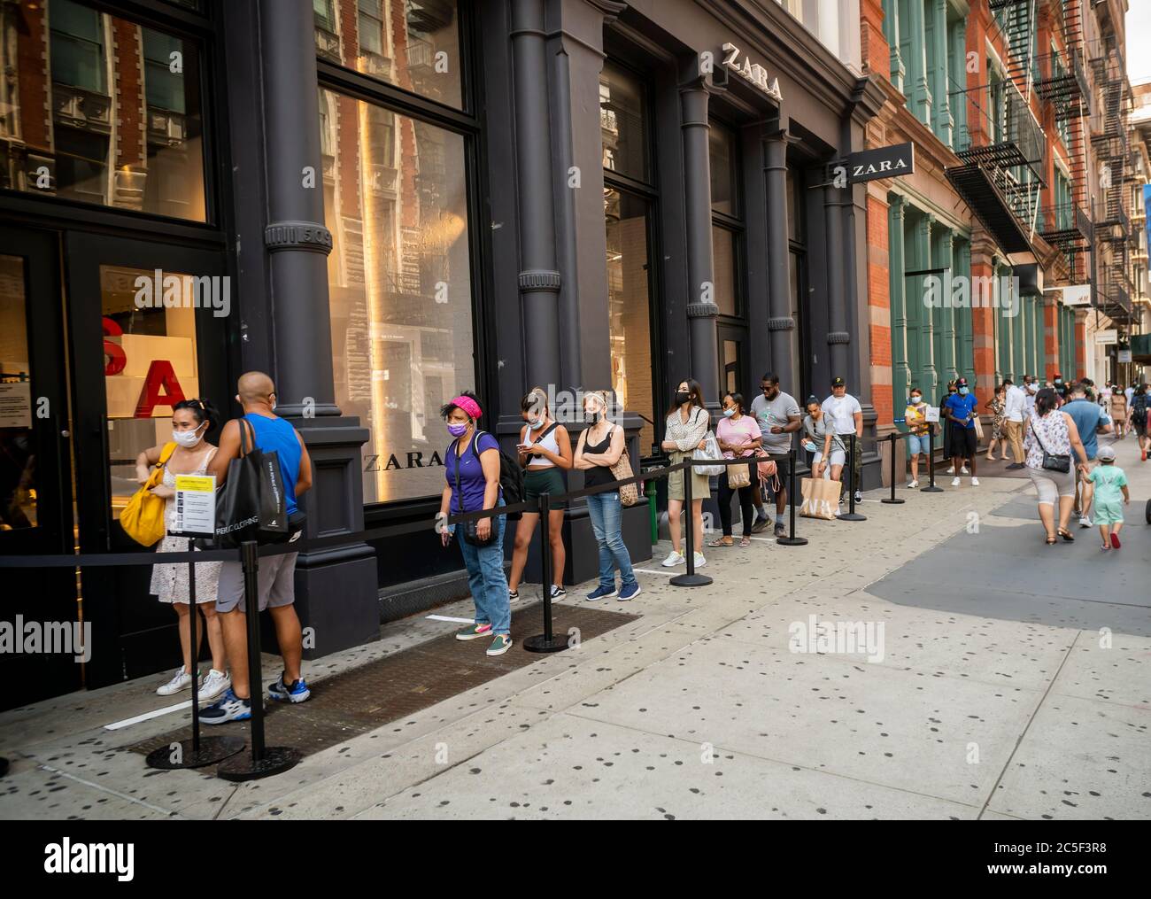 Line outside a Zara store in Soho in New York on Sunday, June 28, 2020 as  stores open, with capacity restrictions, during Phase Two of the city's  reopening. (© Richard B. Levine