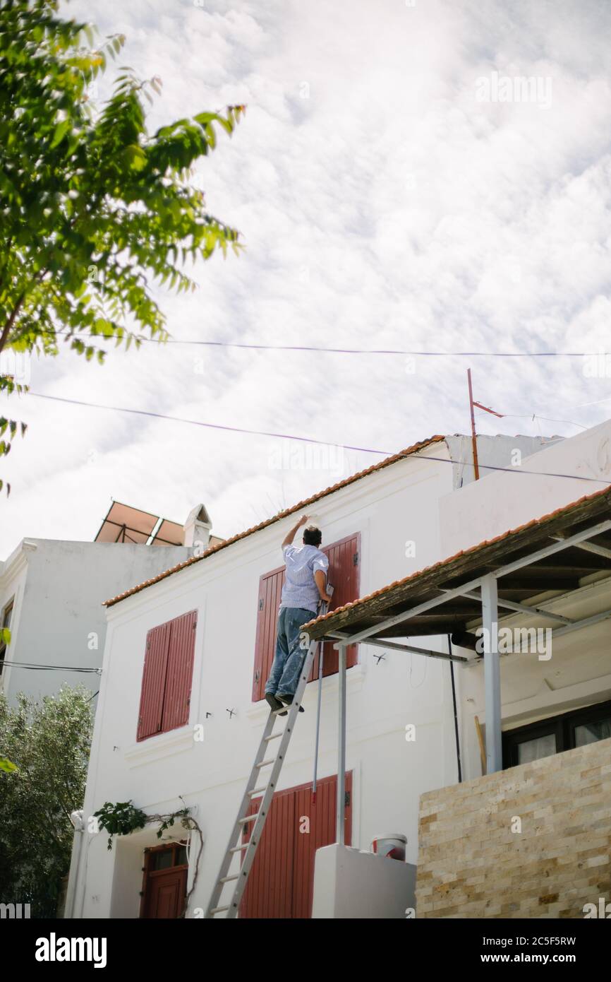 Man painting the wall. The man repairs the house. Repair and renovation