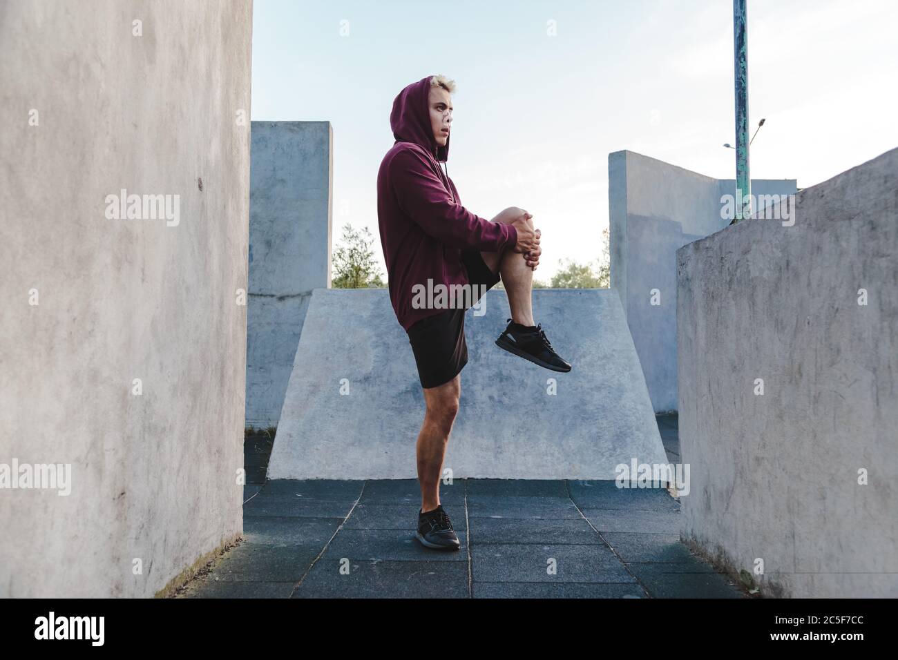Sporty young man stretching muscles hi-res stock photography and images ...