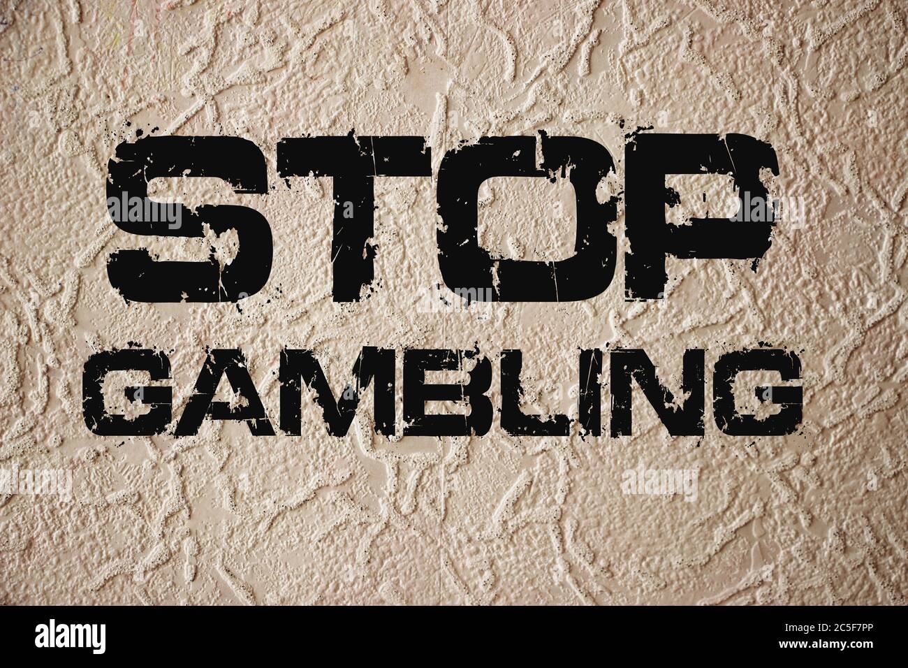 Stop gambling phrase sign on old texturized wall. Qut addiction concept on grunge background Stock Photo
