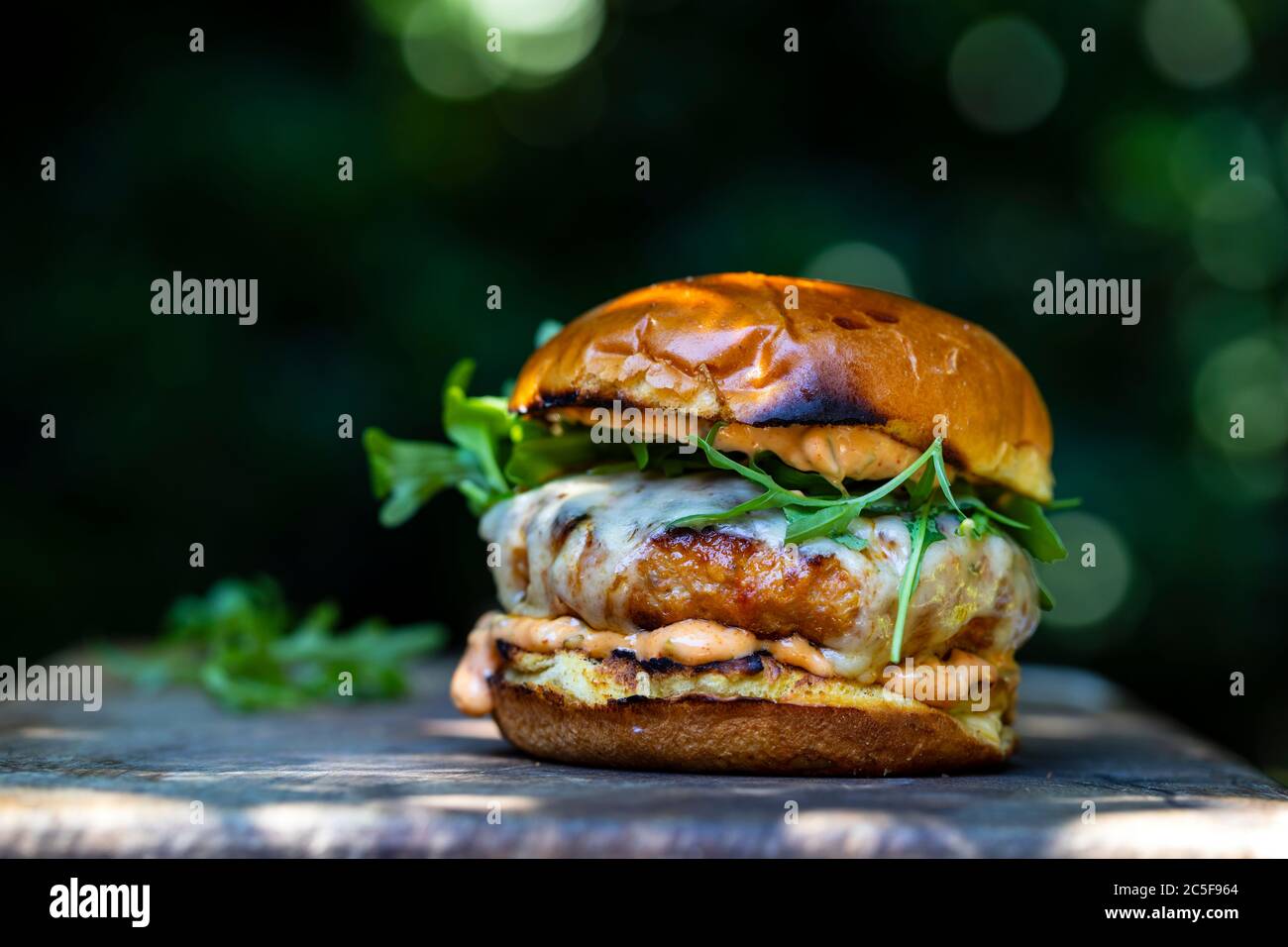 Pork and chorizo burger with cheese in brioche bun Stock Photo
